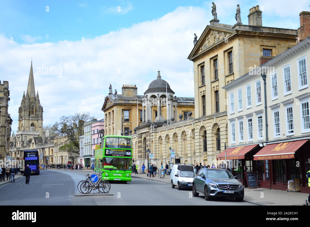 Die High Street in Oxford mit beweglichen Grün Double Decker Bus und Fahrrad geparkt. Blick auf den Queen's College und der Kirche St. Maria, der Jungfrau, Stockfoto