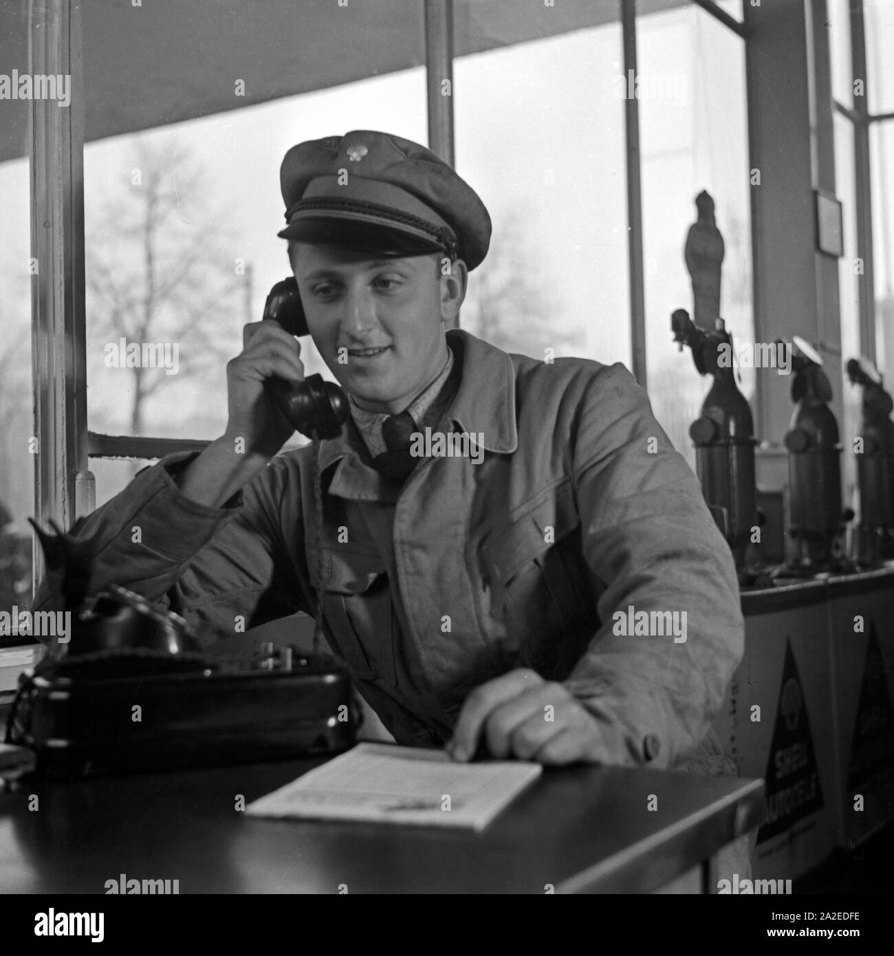 Der freundliche Mann von der Shell Tankstelle am Telefon, Deutschland 1930er Jahre. Die freundlichen Mitarbeiter an der Shell Tankstelle am Telefon, Deutschland 1930. Stockfoto