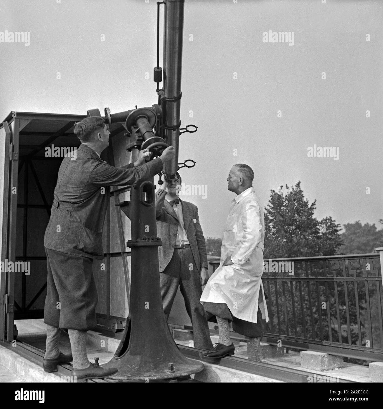 Mitarbeiter der Sternwarte Berlin Treptow justieren das Kleinteleskop auf  dem Dach, Deutschland 1930er Jahre. Mitarbeiter der Berlin Treptow  Sternwarte einstellen ein kleineres Teleskop auf dem Dach, Deutschland 1930  Stockfotografie - Alamy