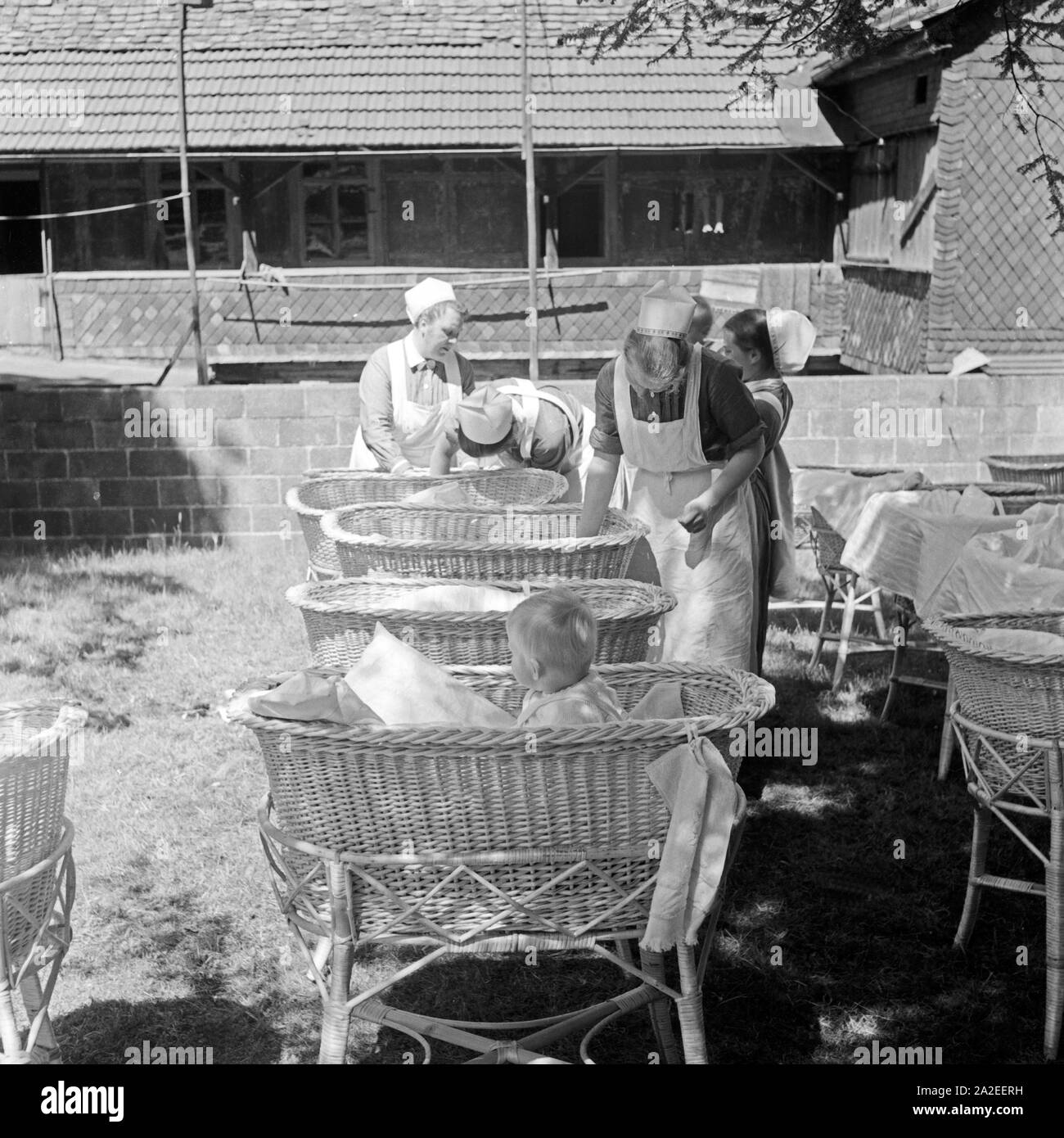 Krankenschwestern kümmern sich um Kleinkinder im Garten vom Haus der deutschen Mutter in Elgersburg, Thüringen, 1930er Jahre. Krankenschwestern die Betreuung für Kleinkinder im Garten am Haus der deutschen Mutter Mutter und Kind Freizeit Home in Elgersburg Thurinigia, 1930er Jahre. Stockfoto