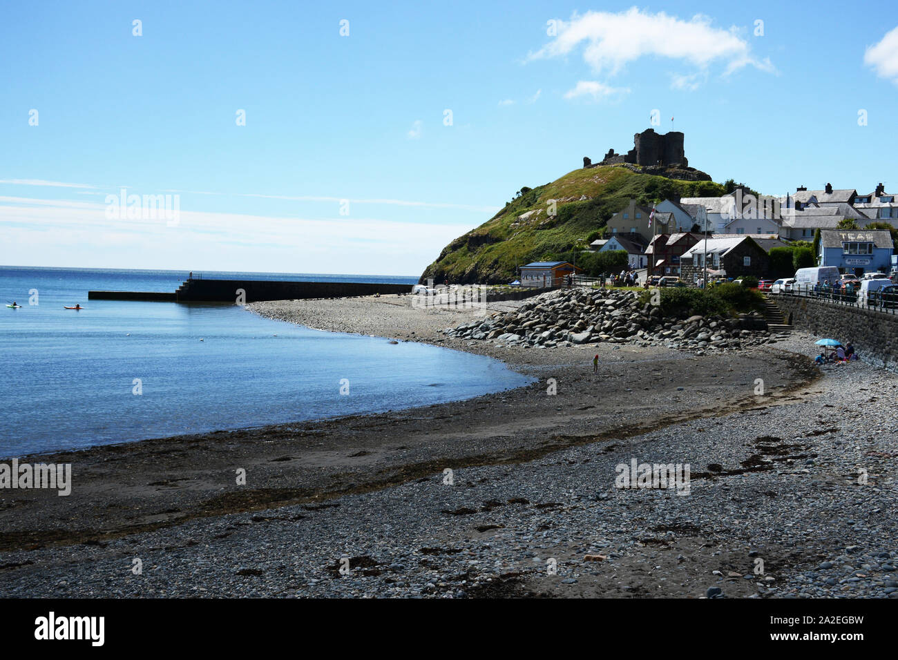 Blick über den Strand mit Criccieth Castle auf dem Hügel in der Ferne. Stockfoto