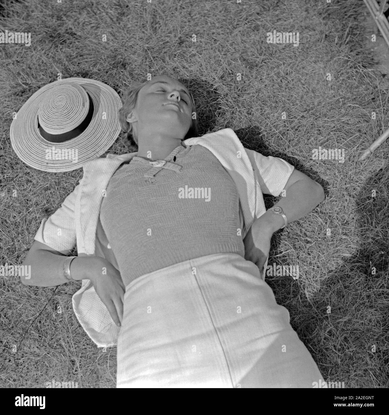 Eine junge Frau bei einem Sonnenbad auf einer Wiese in Berlin, Deutschland, 1930er Jahre. Eine junge Frau, Sonnenbaden an einem Rasen in Berlin, Deutschland 1930. Stockfoto