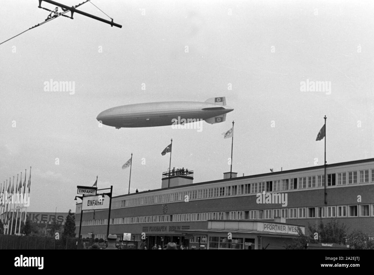 Zeppelin LZ 129 Hindenburg Olympiafahrt bei der über dem Flughafen Berlin Tempelhof, Deutschland 1930er Jahre. Zeppeilin Hindenburg LZ 129 auf seiner olympischen Fahrt über den Flughafen Tempelhof in Berlin, Deutschland 1930. Stockfoto