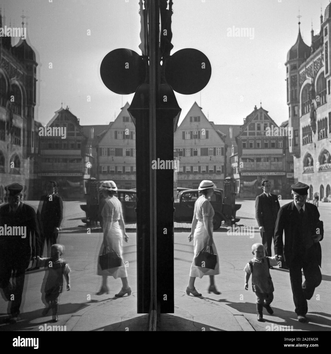 Passanten spiegeln sich im-Schaufenster eines Geschäfts am Marktplatz in Stuttgart, Deutschland, 1930er Jahre. Passanten in einem Schaufenster am Markt widerspiegeln in der Stadt Stuttgart, Deutschland 1930. Stockfoto