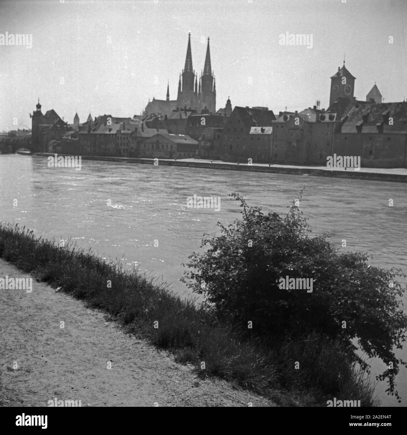 Blick auf das Panorama von Regensburg mit der Donau, dem Dom und dem Uhrturm am Alten Rathaus, Deutschland 1930er Jahre. Regensburg Skyline mit Kathedrale, Fluss Daunbe und der Turm des Alten Rathauses, Deutschland 1930. Stockfoto