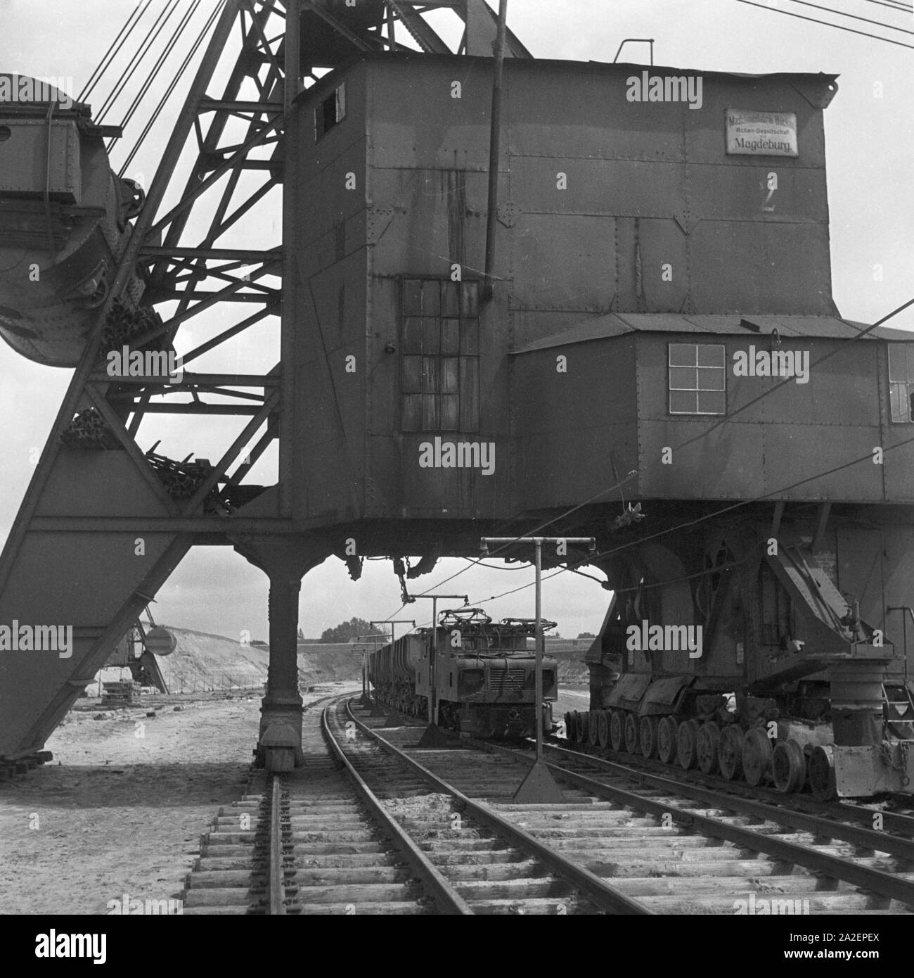 Ein Güterzug, von einer Elektrolokomotive gezogen, wird mit Ladung Bernstein bei Palmnicken im Samland in Ostpreußen befüllt, Deutschland 1930er Jahre. Ein güterzug ist mit Bernstein in Palmnicken in Sambia in Ostpreußen, Deutschland 1930 s geladen Stockfoto