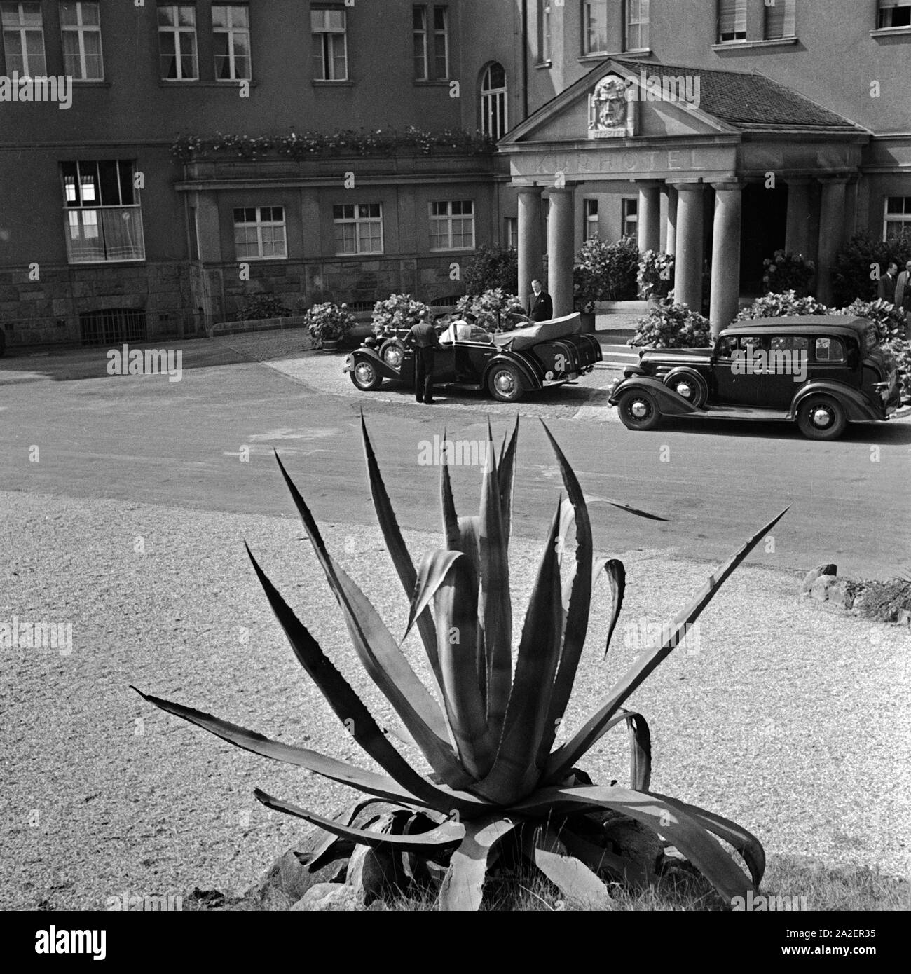 Zwei edle Karossen parken vor dem Kurhotel Mülhens auf dem Petersberg im Siebengebirge bei Bonn, Deutschland 1930er Jahre. Zwei edlen Autos parken am Eingang des Spa Resort Muelhens auf dem Petersberg bei Bonn, Deutschland 1930. Stockfoto