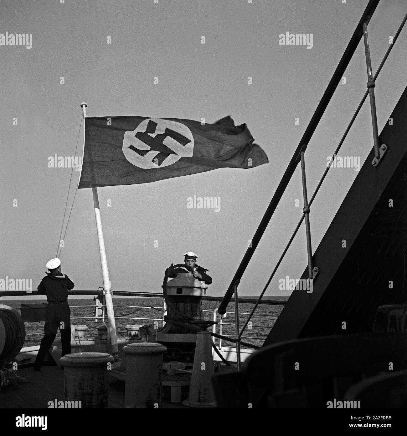Matrosen steuern mein Schiff unter der Reichsflagge, Deutschland 1930er Jahre. Segler Lenkung ein Schiff unter der Hakenkreuzflagge, Deutschland 1930. Stockfoto