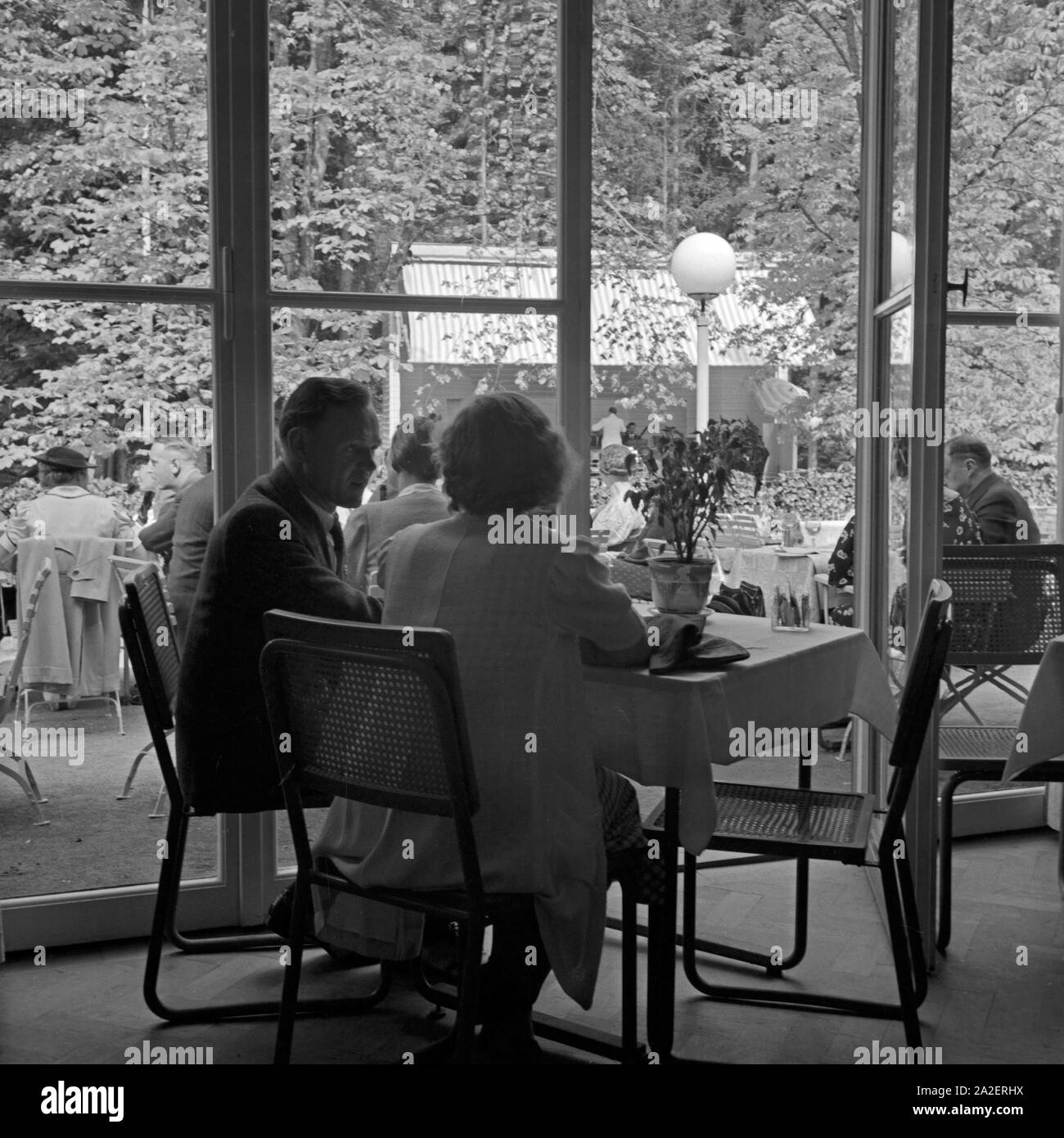 Ein Paar sitzt am Tisch im Restaurant in Wildbad im Schwarzwald, Deutschland 1930er Jahre. Ein paar sitzen in einem Restaurant in Wildbad im Schwarzwald, Deutschland der 1930er Jahre. Stockfoto