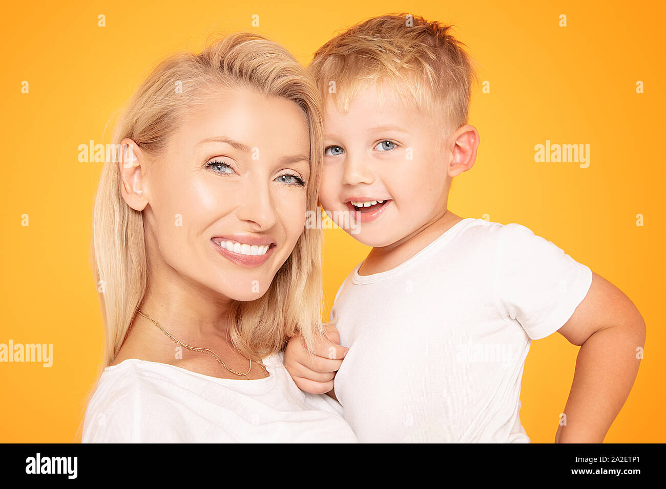 Mutter, Kind Sohn an jedem anderen auf der Suche nach gelb orange Wand Hintergrund isoliert. Fröhliche Frau. Viel Spaß mit Kind Junge. Muttertag, liebe Familie Stockfoto