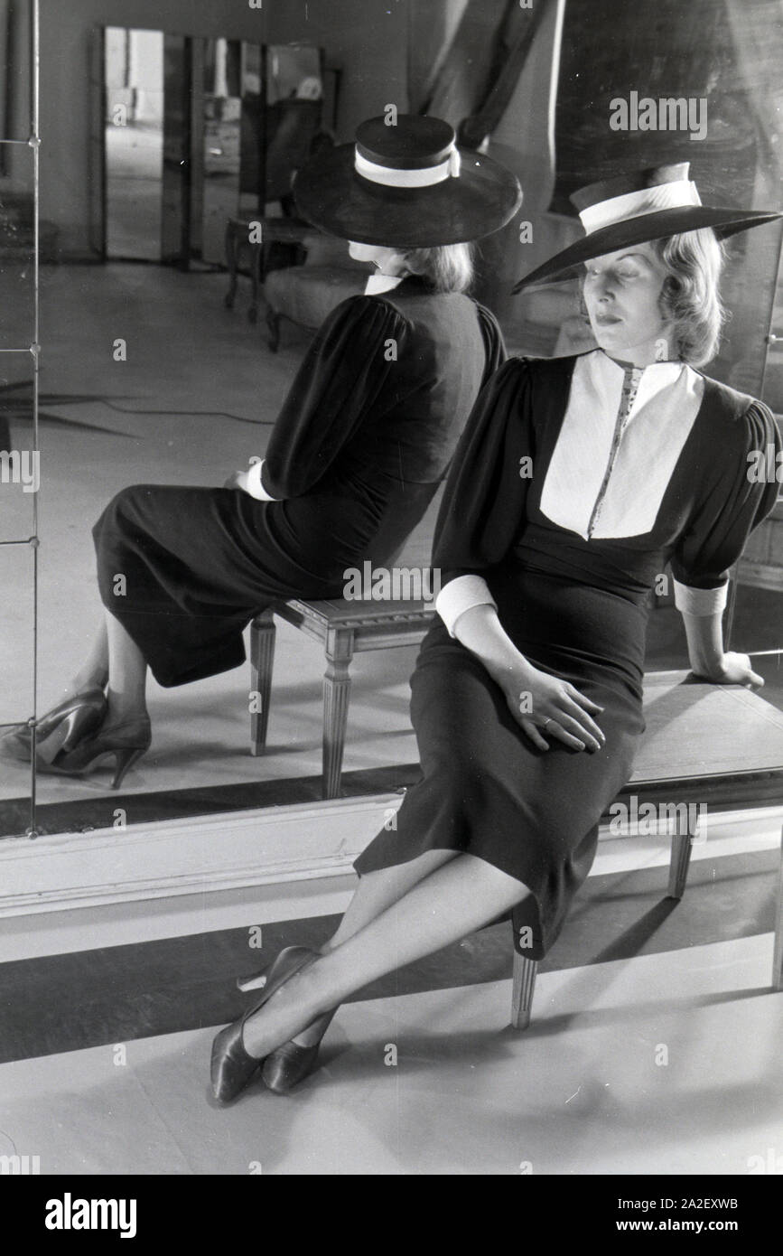 Ein Modell bei der Anprobe eines Kleides des Berliner Modeschöpfers Heinz Schulze-Bibernell, Deutschland Ca. 1939. Ein Modell versucht, ein Kleid von Mode de Stockfoto