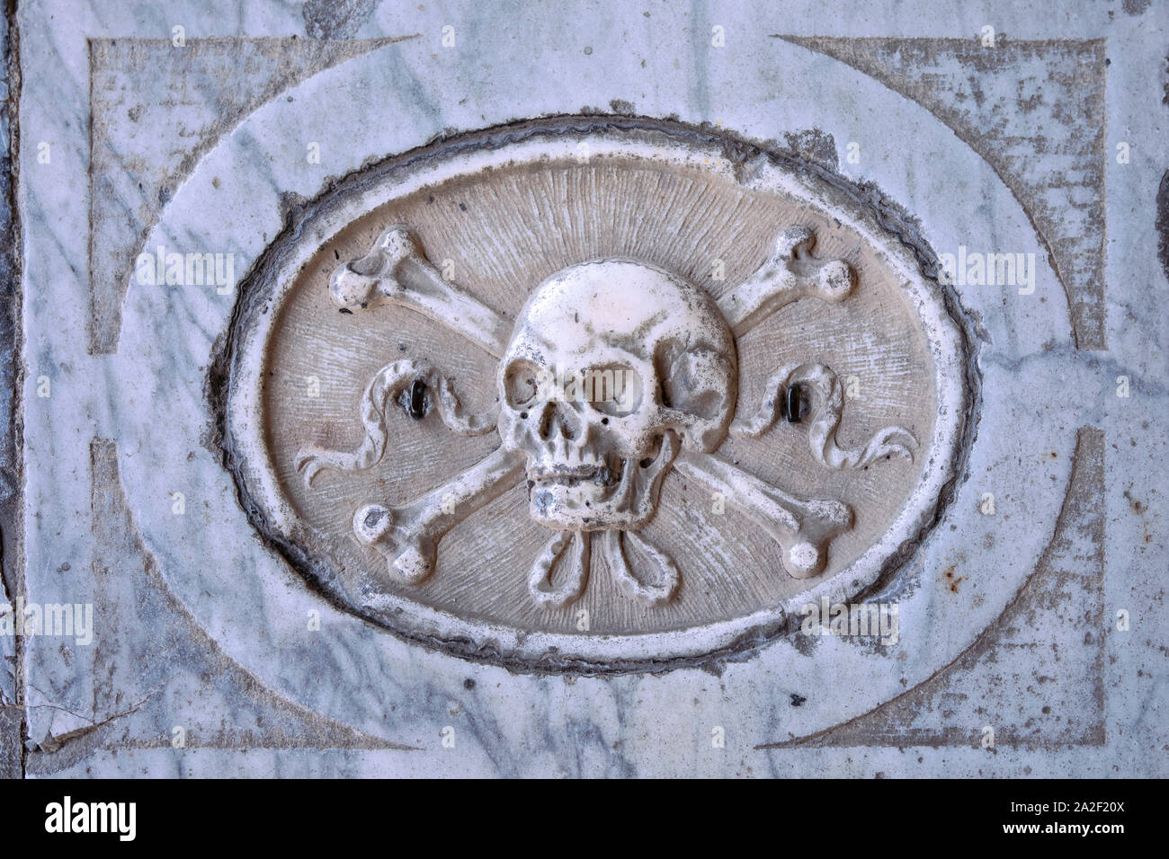 Klassische Totenkopf mit gekreuzten Knochen Symbol in Marmor Stein auf italienischen Grab. Antike mittelalterliche Krypta. Alte Schädel Muster, Memento mori. Retro anmelden Stockfoto