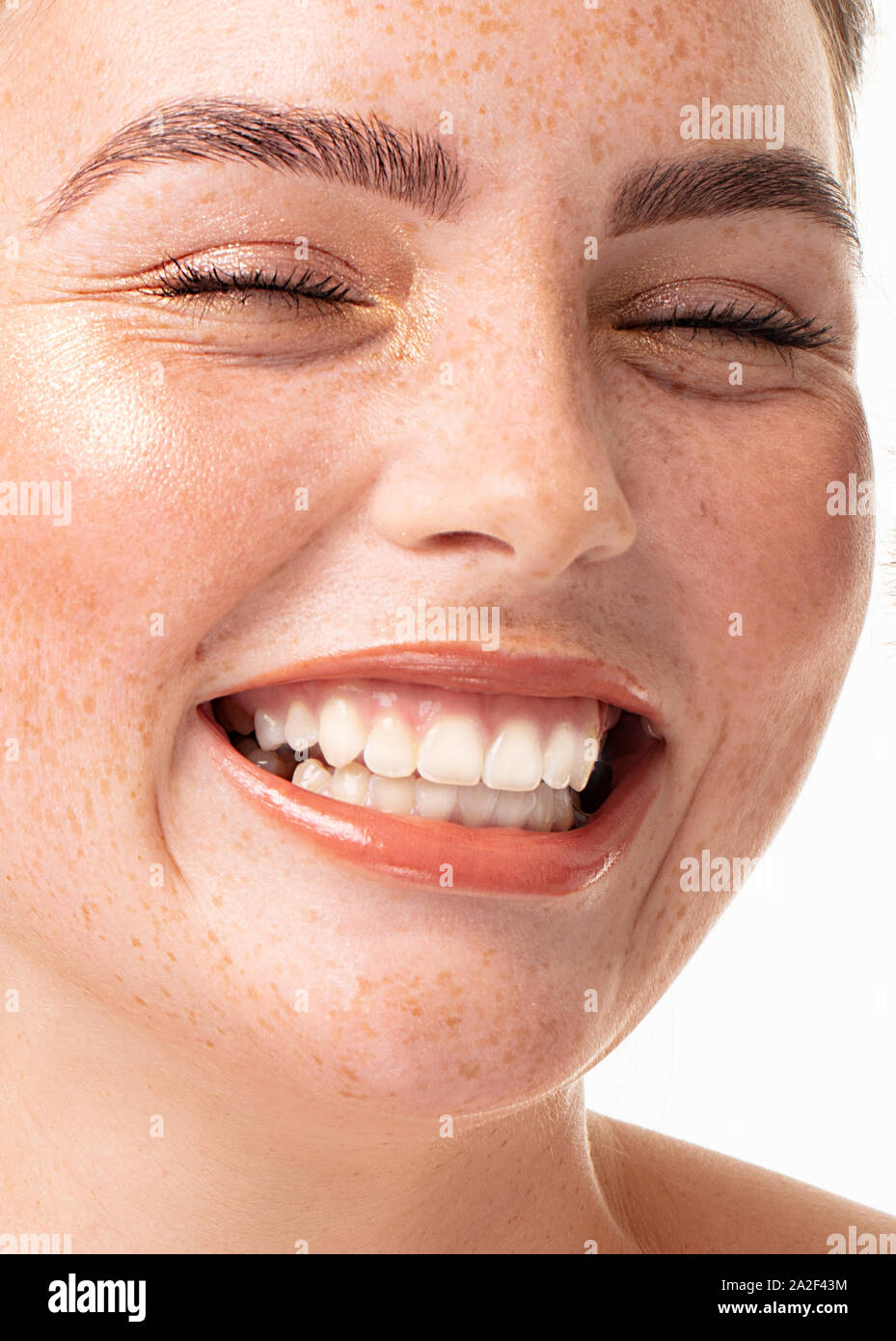 Porträt der schönen jungen Frau mit perfekt sauber gesunde Haut und langen Wimpern. Nahaufnahme Gesicht des Mädchens mit Sommersprossen. Rothaarige Dame mit toothy Lächeln. Stockfoto