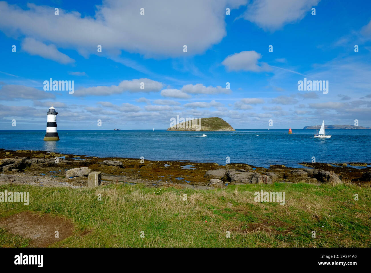 Der östliche Endpunkt von Anglesea, die die Passage zwischen dem Ufer und Papageitaucher Insel mit Leuchtturm Penmon Stockfoto