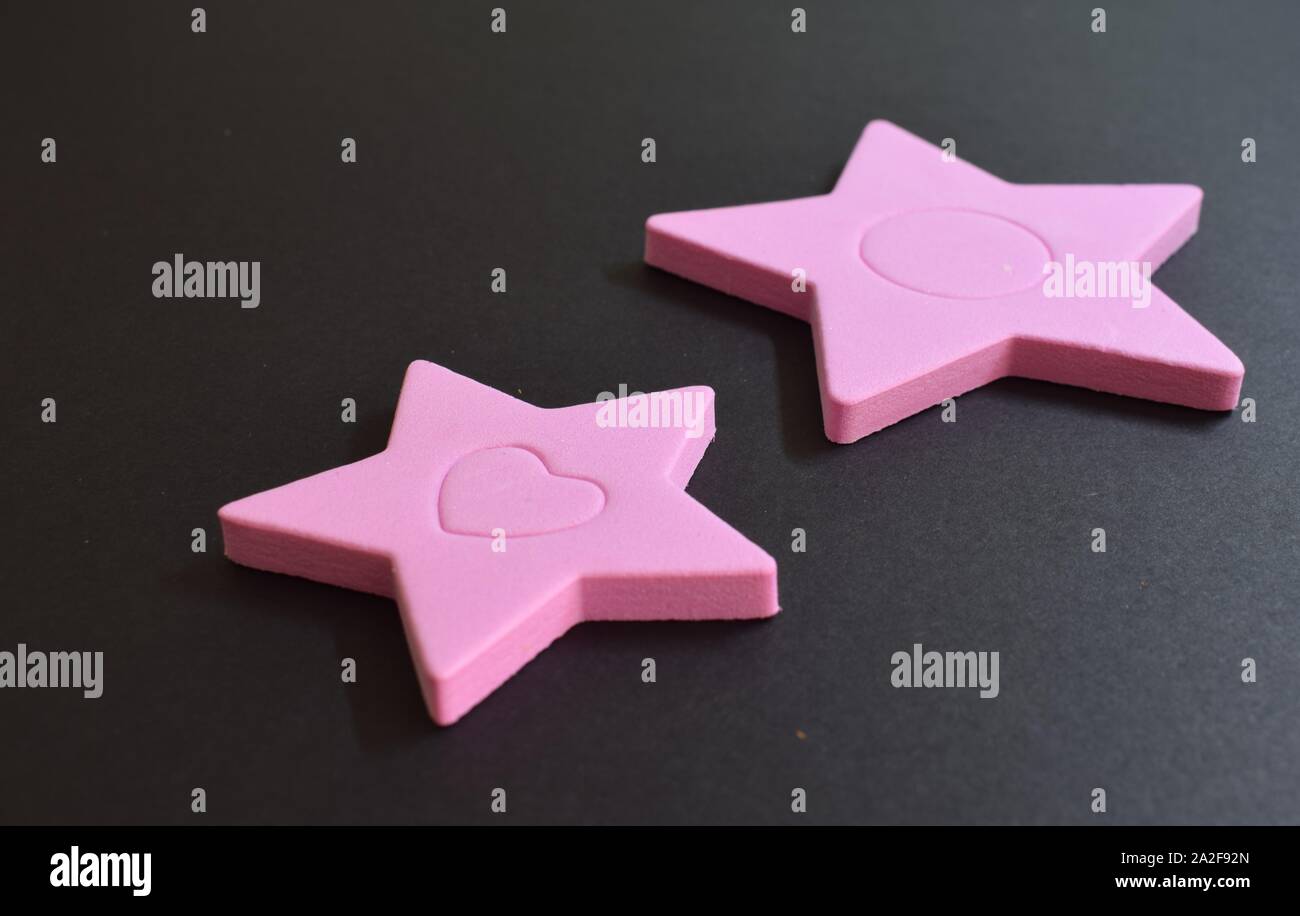 Eva Gummi rosa Sterne auf schwarzem Hintergrund Stockfoto