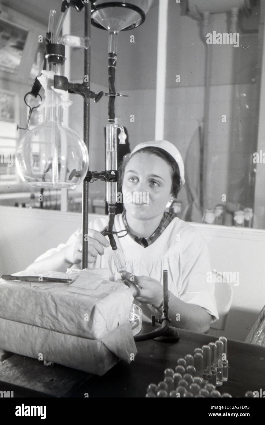 Eine Laborantin fertigt in Arbeit der Behringwerke Proben eines Medikaments ein, Marburg, Deutschland 1930er Jahre. Eine Lab Assistant ist die Einnahme von Medikamenten Proben im Labor der Behringwerke, Marburg, Deutschland 1930. Stockfoto