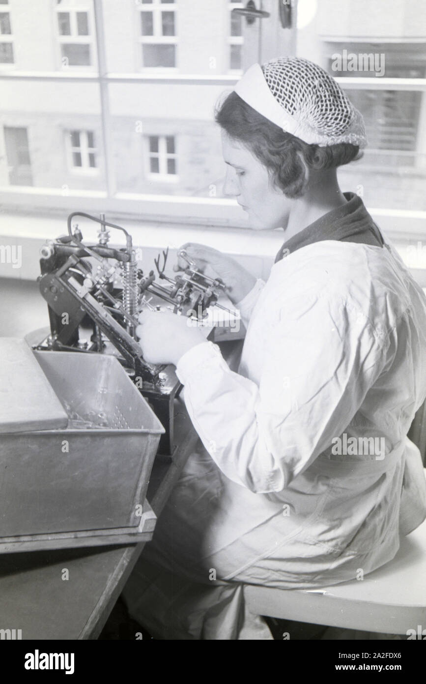 Eine Laborantin fertigt in Arbeit der Behringwerke mithilfe einer technischen Apparatur Proben eines Medikaments ein, Marburg, Deutschland 1930er Jahre. Eine Lab Assistant ist die Einnahme von Medikamenten Proben mit Hilfe der ein technisches Instrument im Labor der Behringwerke, Marburg, Deutschland 1930. Stockfoto