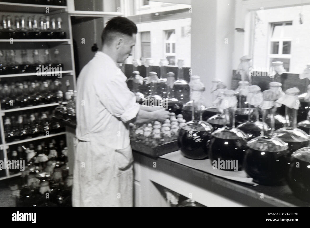 Ein Laborant beschriftet abgefüllte Medikamentenproben in Arbeit der Behringwerke, Marburg, Deutschland 1930er Jahre. Eine Lab Assistant ist die Etikettierung der Flasche Medizin Proben in ein Labor der Behringwerke, Marburg, Deutschland 1930. Stockfoto