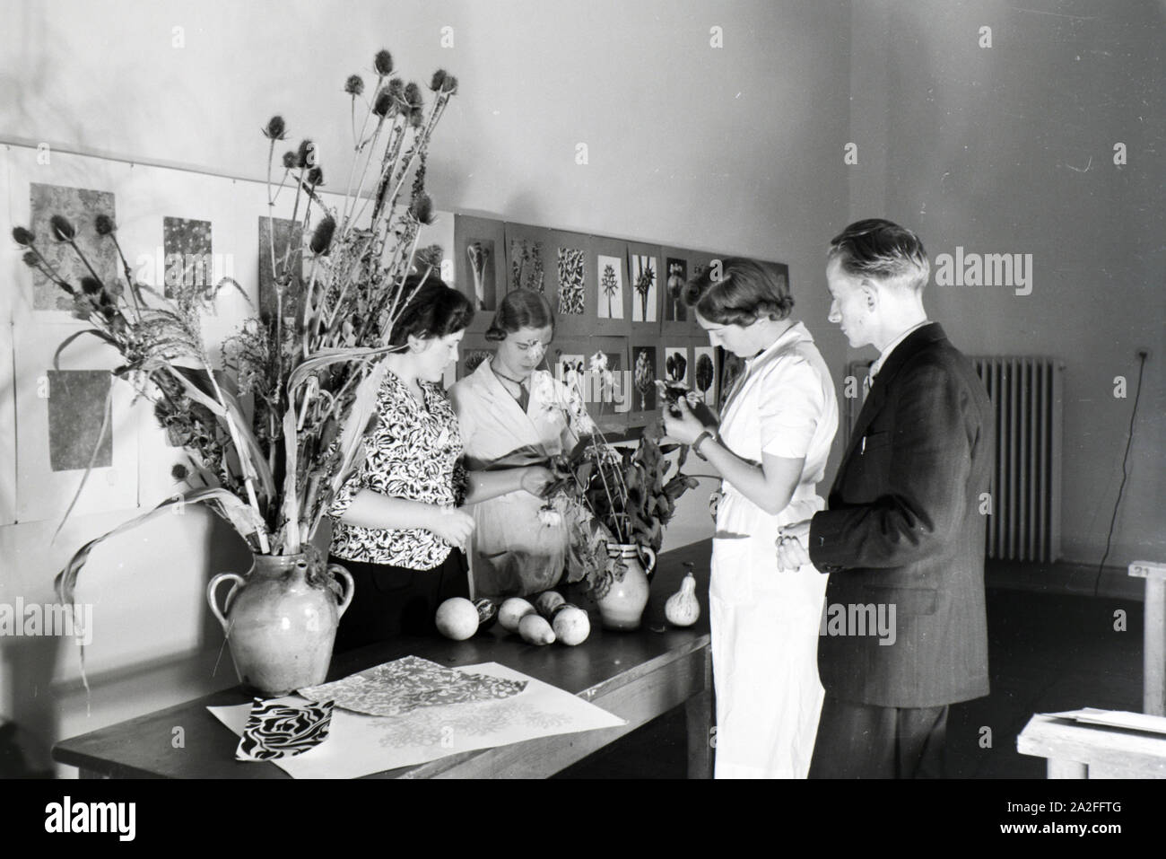 In einer Krefelder Textilfirma entwerfen sterben Lehrlinge anhand von Trockenblumen und Gemüse neue Motive und Muster für die Stoffproduktion, Deutschland 1930er Jahre. Auszubildende einer Textilfabrik in Krefeld entwerfen neue Muster für die Textilindustrie auf Gemüse basieren und getrockneten Blumen, Deutschland 1930. Stockfoto