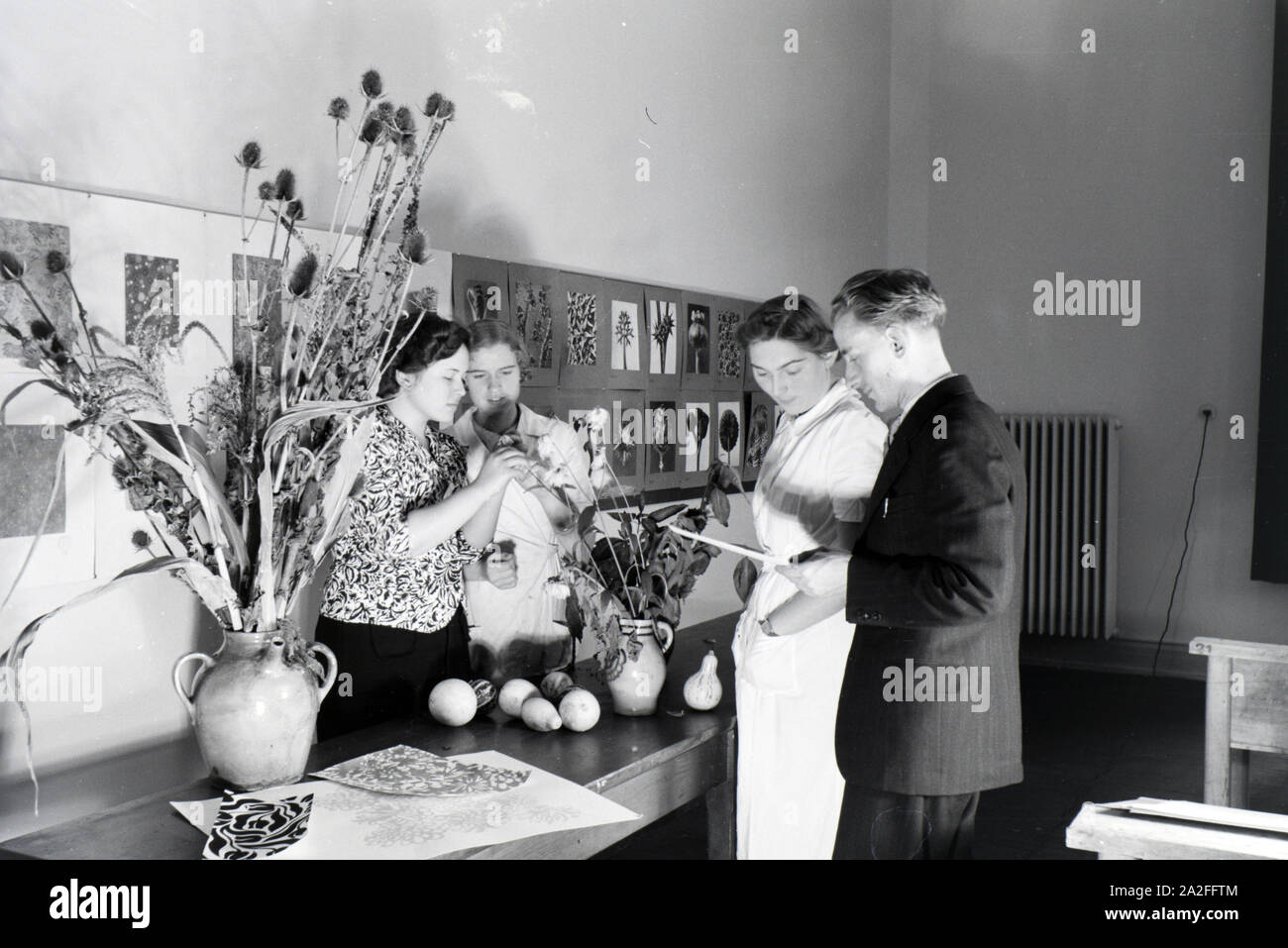 In einer Krefelder Textilfirma entwerfen sterben Lehrlinge anhand von Trockenblumen und Gemüse neue Motive und Muster für die Stoffproduktion, Deutschland 1930er Jahre. Auszubildende einer Textilfabrik in Krefeld entwerfen neue Muster für die Textilindustrie auf Gemüse basieren und getrockneten Blumen, Deutschland 1930. Stockfoto