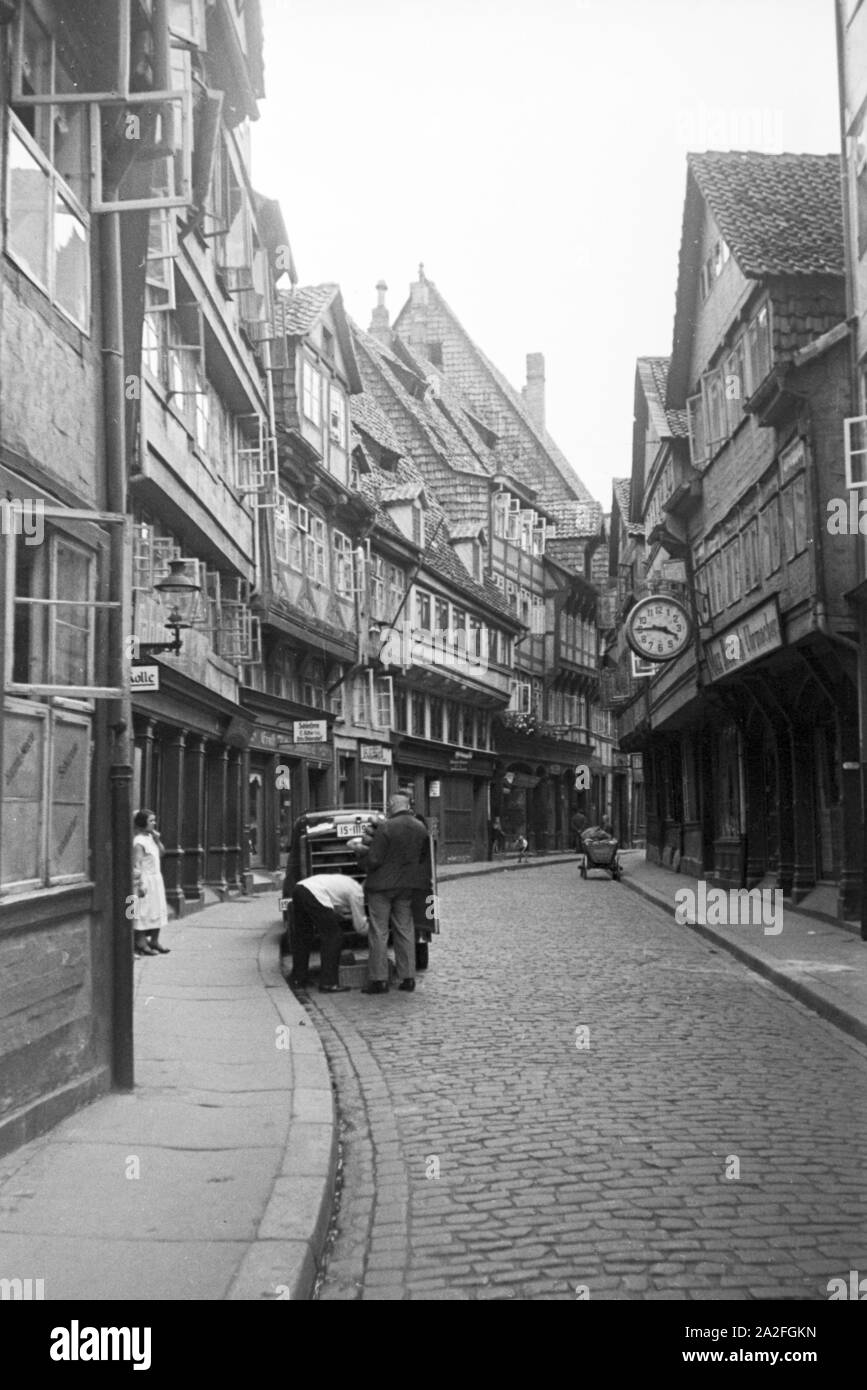 Eine Gasse mit zahlreichen Geschäften in alten Fachwerkbauhäusern in Braunschweig, Deutschland 1930er Jahre. Eine Gasse mit zahlreichen Geschäften in alte Fachwerkhäuser in Braunschweig, Deutschland 1930. Stockfoto