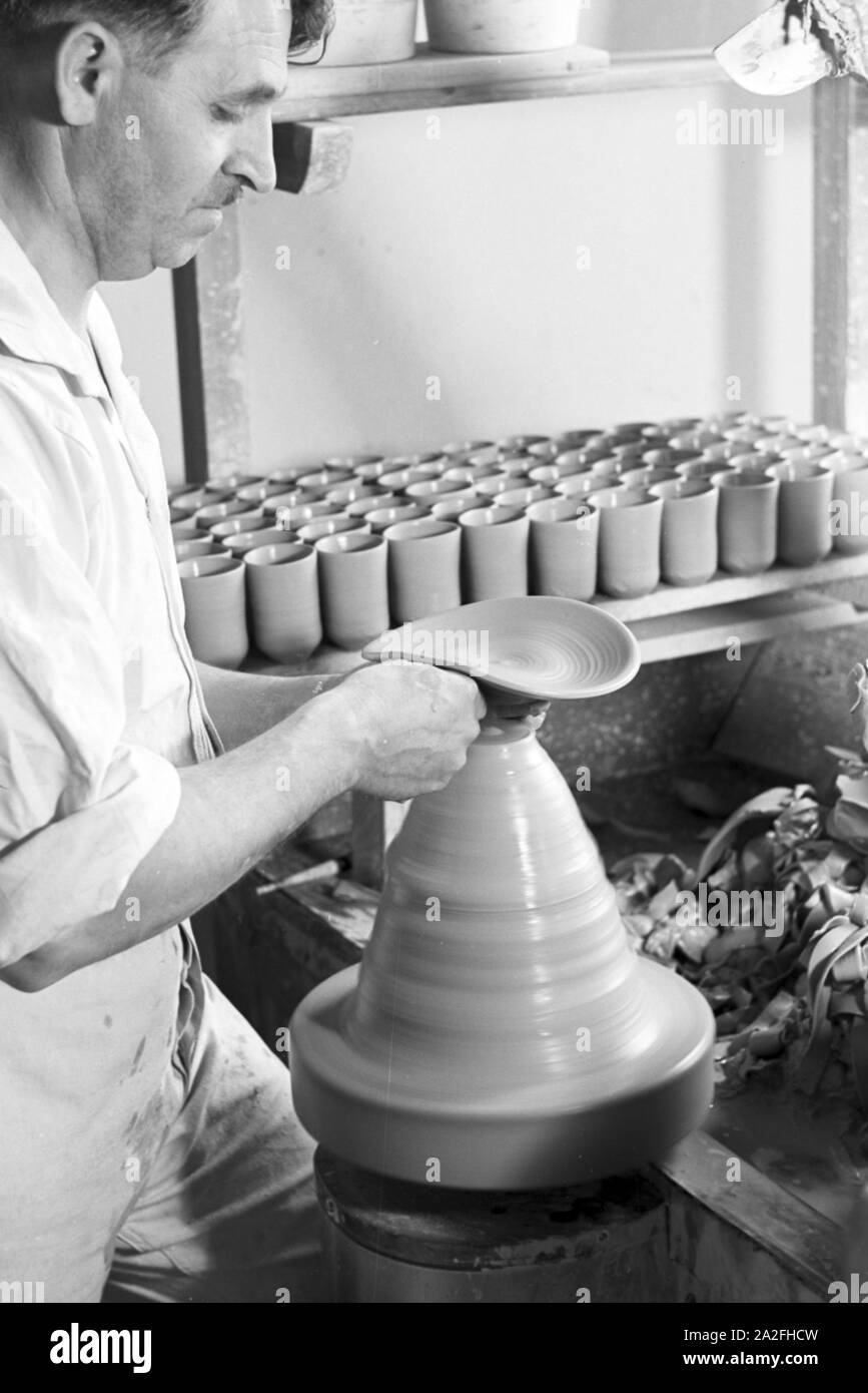 Ein Töpfer der Staatlichen Porzellanmanufaktur Berlin bei der Arbeit an der Töpferscheibe, Deutschland 1930er Jahre. Ein Potter der Staatlichen Porzellanmanufaktur Berlin arbeiten an der Töpferei Rad, Deutschland 1930. Stockfoto