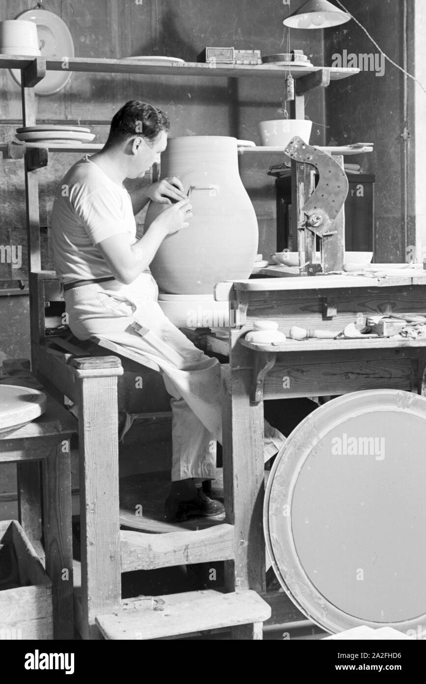 Ein Keramiker der Staatlichen Porzellanmanufaktur Berlin bei der Arbeit ein einer großen Vase, Deutschland 1930er Jahre. Keramikerin der Staatlichen Porzellanmanufaktur Berlin arbeiten auf einer großen Vase, Deutschland 1930. Stockfoto