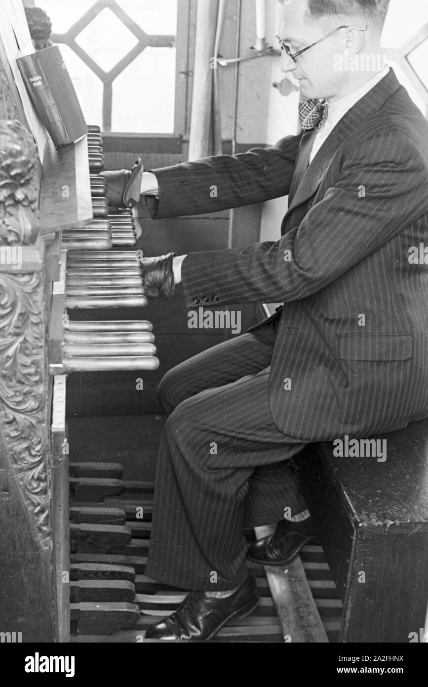 Ein Organist am Spieltisch der Kirchenorgel in der Parochialkirche in Berlin, Deutschland, 1930er Jahre. Ein Organist an der Konsole der Orgel in der Parochialkirche in Berlin, Deutschland 1930. Stockfoto