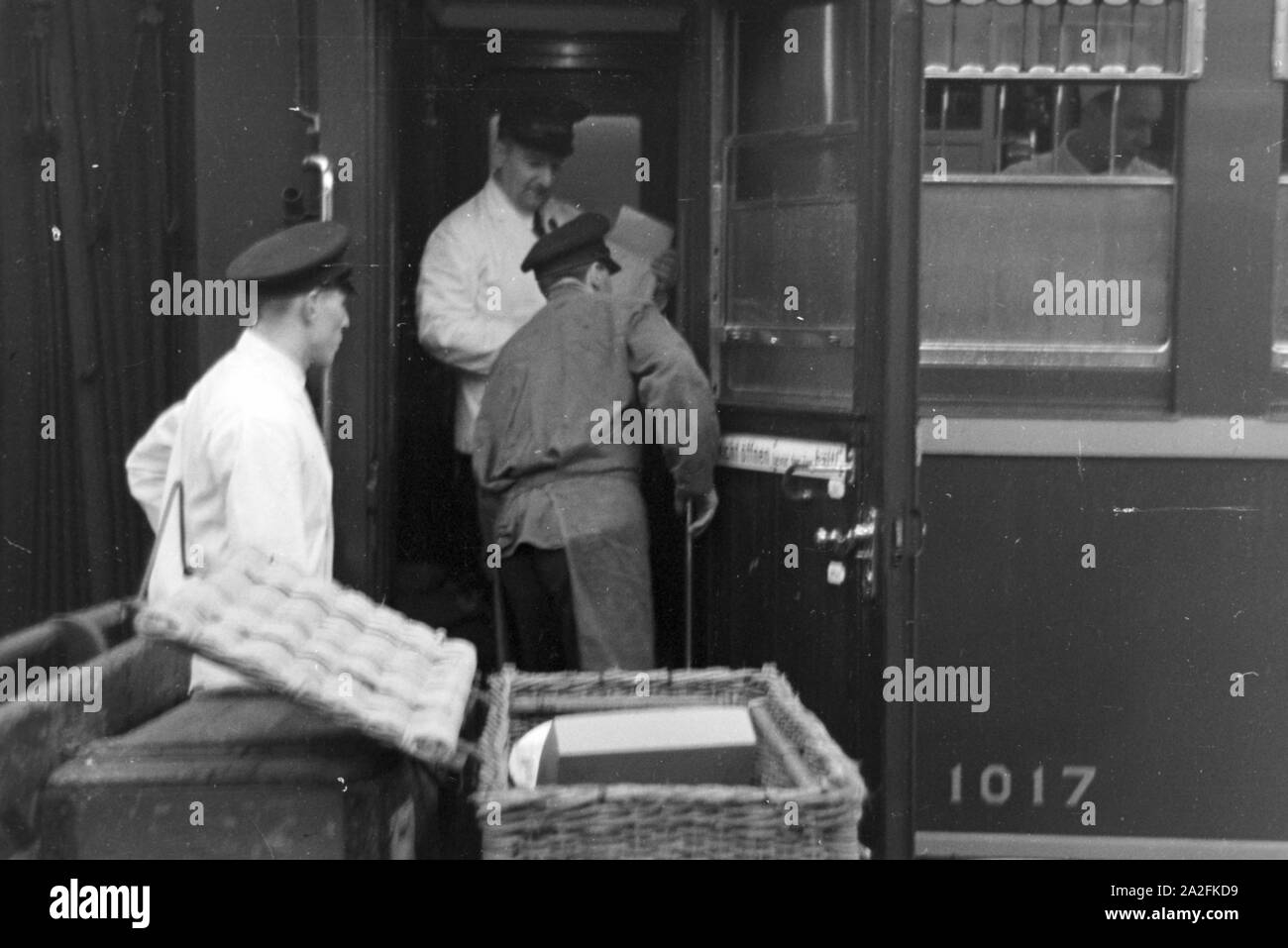 Mitarbeiter der Mitropa bei der Bestückung des Speisewagens auf dem Bahnhof, Deutschland 1930er Jahre. Mitarbeiter Ladetechnik für die mitropa Speisewagen, Deutschland 1930. Stockfoto