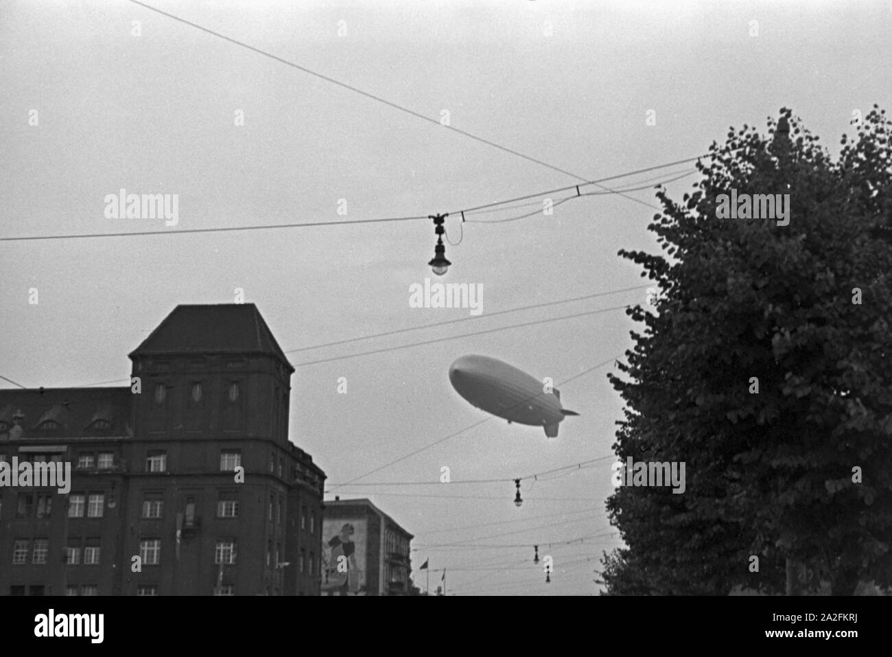 Zeppelin LZ 129 Hindenburg bei der olympiafahrt über Berlin, Deutschland 1930er Jahre. Zeppeilin Hindenburg LZ 129 auf seiner olympischen Fahrt über Berlin, Deutschland 1930. Stockfoto