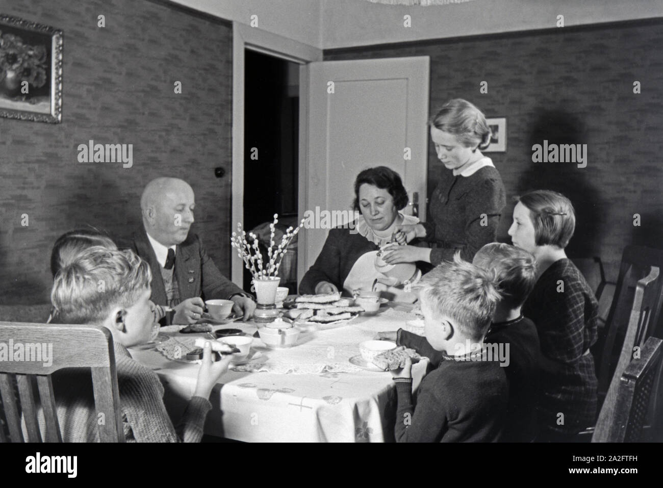 Mitglieder einer kinderreichen Familie bei Kaffe und Kuchen, Deutsches Reich 30er Jahre. Mitglieder einer Großfamilie mit Kaffee und Kuchen, Deutschland 1930. Stockfoto