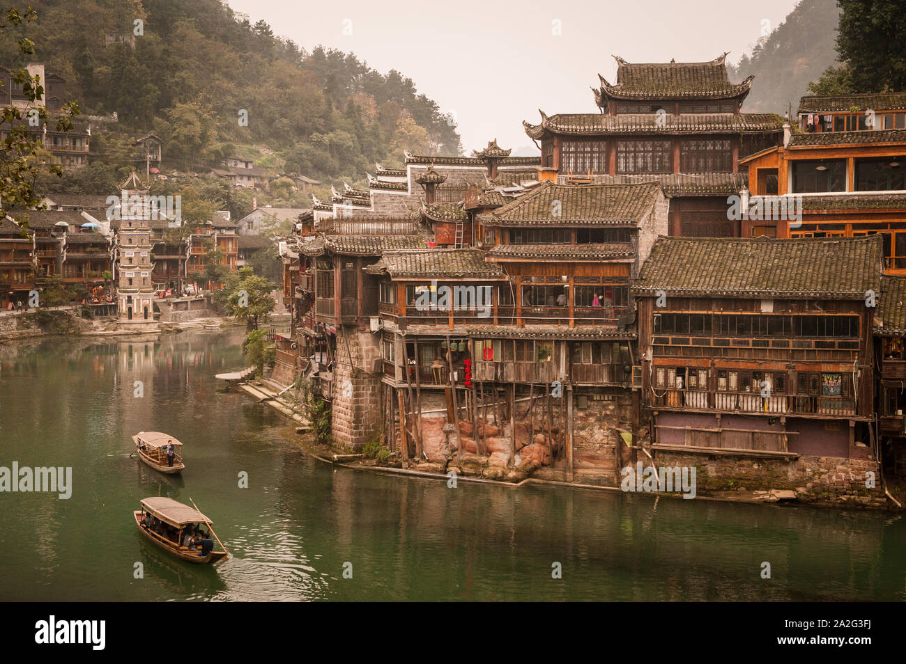 Hunan, China, 14. November 2011: Boote aus Holz nach unten segeln Fluss in Phoenix, alten Stadt. Alle drehen sie in Phoenix Ancient Town ist eine malerische mome Stockfoto