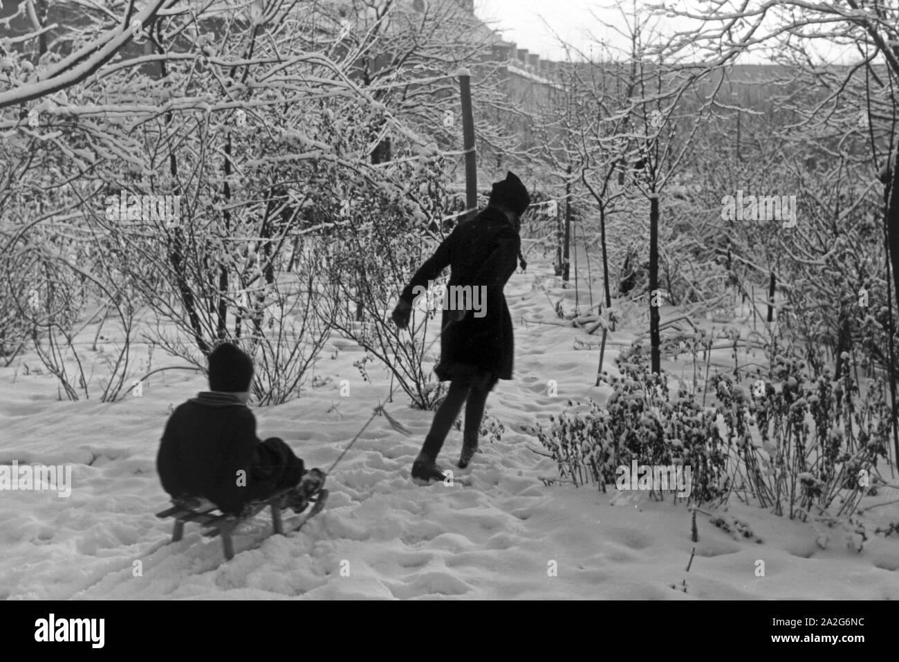 Zwei Kinder spielen im Schnee, Deutschland 1930er Jahre. Zwei Kinder spielen im Schnee, Deutschland 1930. Stockfoto