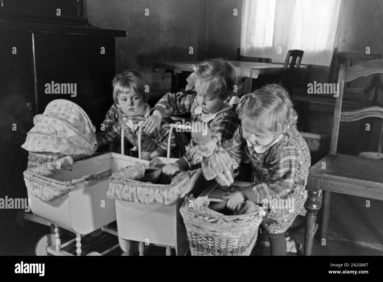 Sterben Knipser Vierlinge als Kleinkinder mit Stand Puppenwagen,  Deutschland 1930er Jahre. Knipser des quadruplet Mdchen mit Kinderwagen  auf Ihre Puppe, Deutschland 1930 Stockfotografie - Alamy