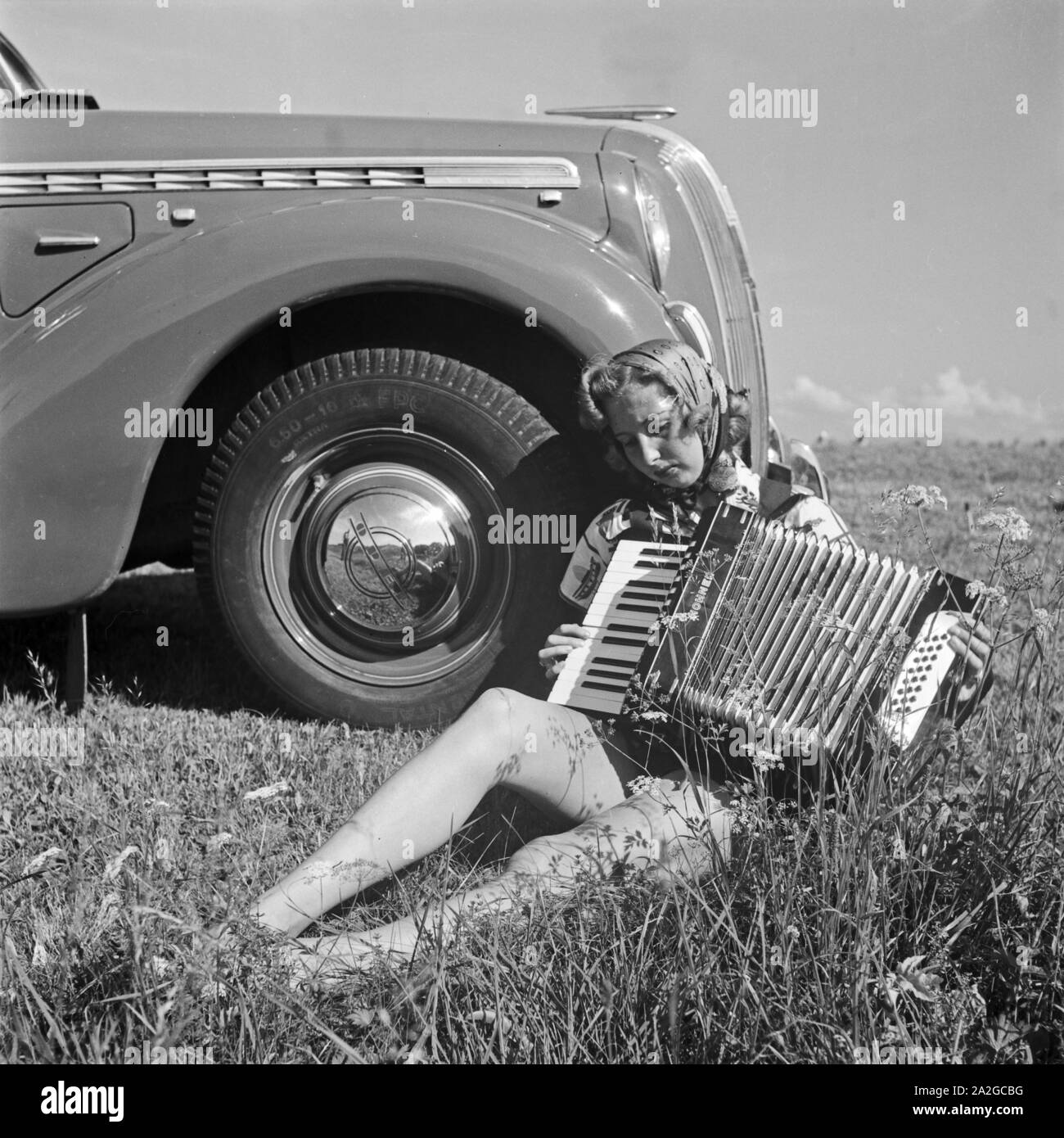 Eine Junge Frau Mit Einem Akkordeon Vor Einem Opel Admiral, 1930er Jahre Deutschland. Eine junge Frau, die durch ein Opel-Modell Admiral, Deutschland 1930er Jahren Akkordeon zu spielen. Stockfoto