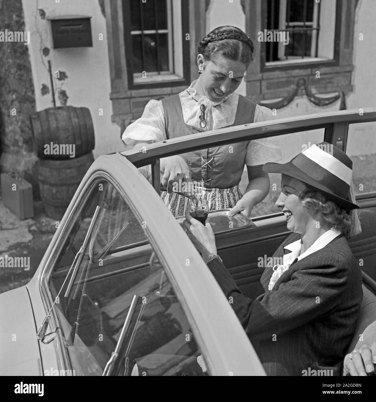 Kleine Weinverkostung und Beifahrerin des Opel Olympia, Österreich, 1930er Jahre. Weinprobe, die für einen Fluggast eines Opel Olympia, Österreich, 1930. Stockfoto