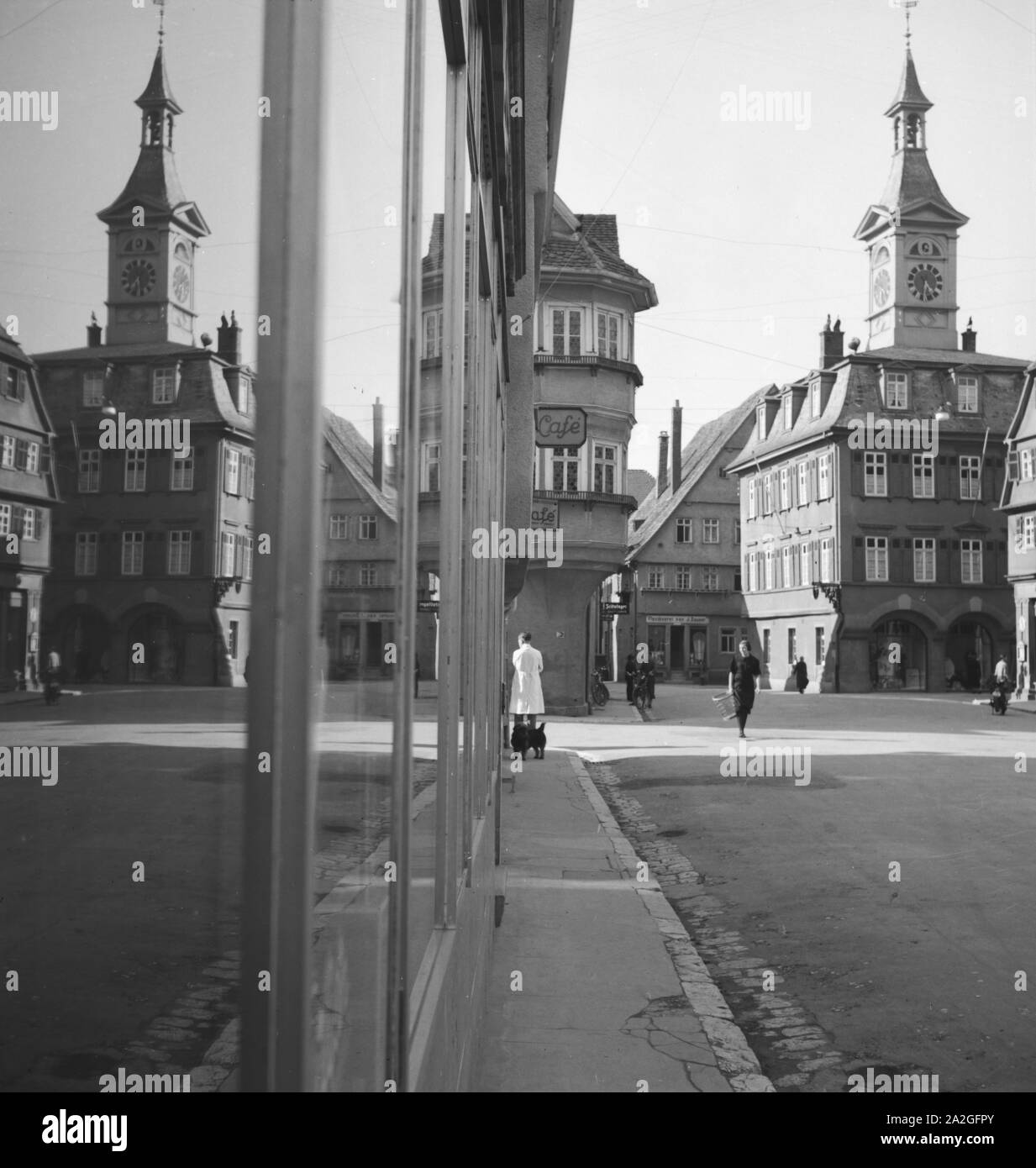 Eine Kleinstadt spielgelt sich im-Schaufenster eines Geschäfts, Deutschland 1930er Jahre. Eine kleine Stadt im Schaufenster auf einer Einkaufsstraße widerspiegelt, Deutschland 1930. Stockfoto