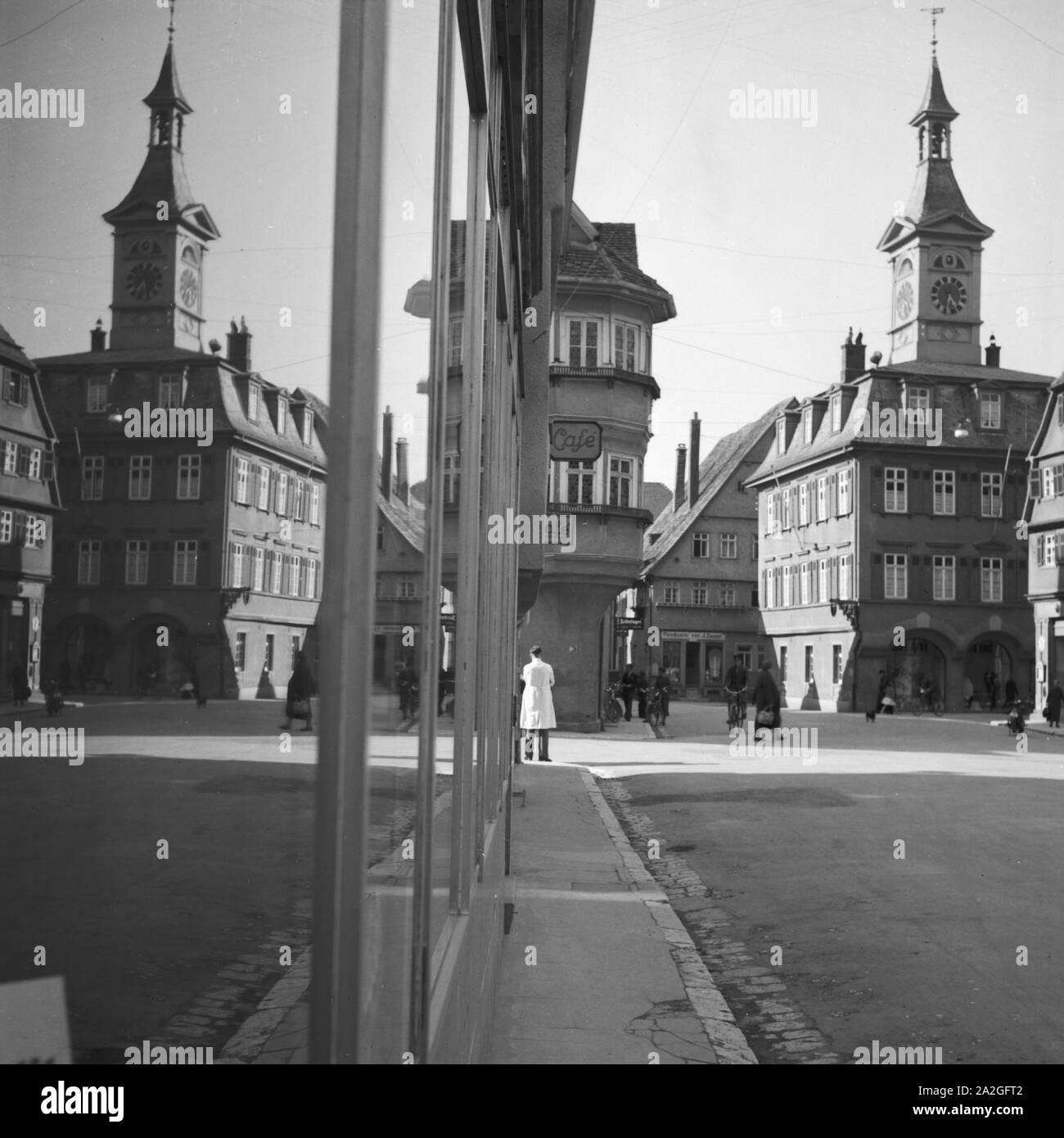 Eine Kleinstadt spiegelt sich im-Schaufenster eines Geschäfts, Deutschland 1930er Jahre. Eine kleine Stadt im Schaufenster auf einer Einkaufsstraße widerspiegelt, Deutschland 1930. Stockfoto