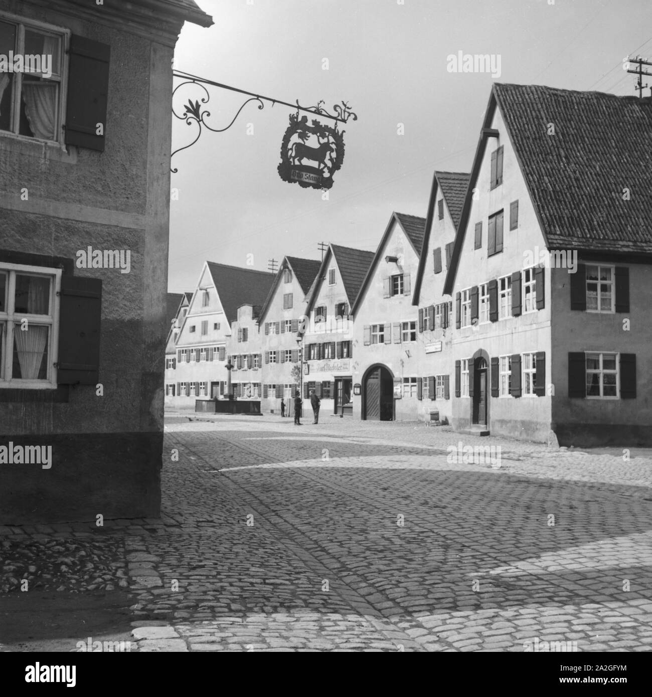 Dorfstraße mit Gebäuden in einer Kleinstadt, Deutschand 1930er Jahre. Ländliche Straße in einer kleinen Stadt, Deutschland 1930. Stockfoto