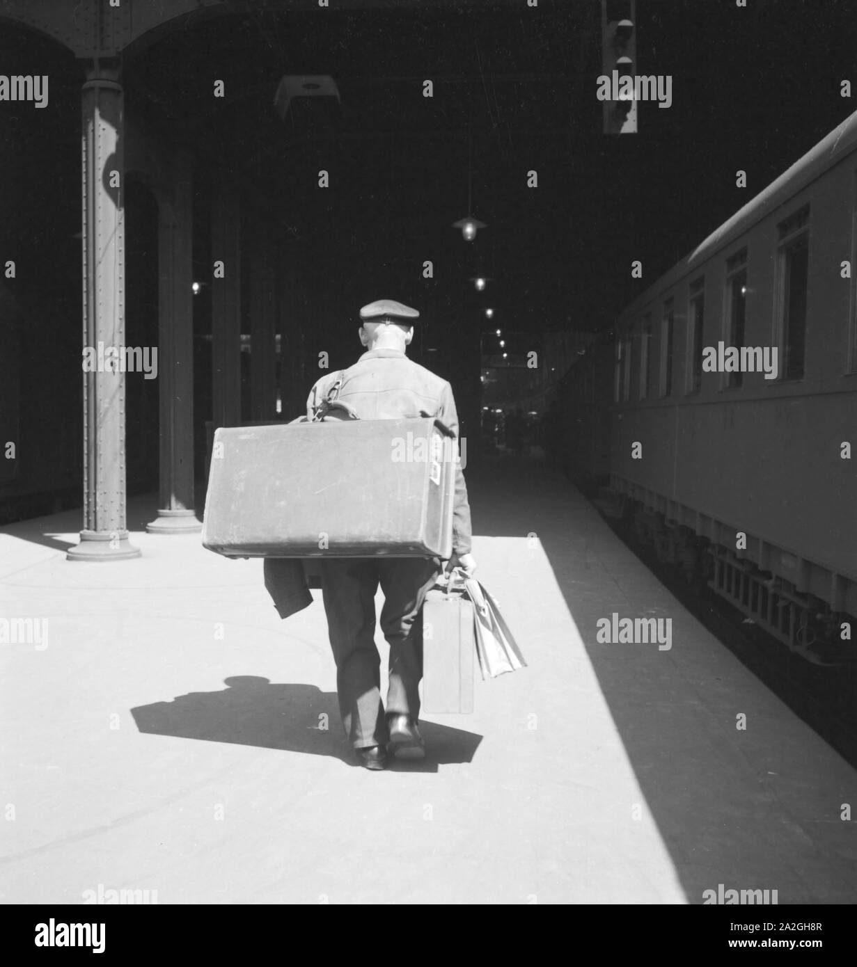 Gepäckträger mit dem zugangsweg am Bahnhof in Hamburg, Deutschland 1930er Jahre. Gepäckträger auf einer Plattform des Hamburger Hauptbahnhofs, Deutschland 1930. Stockfoto