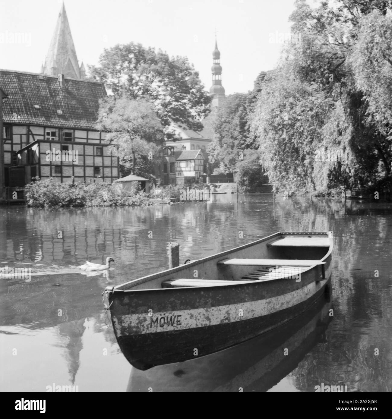 Das Ruderboot 'Möwe' Balatonfüred mit dem Wasser in Soest mit Blick auf den St. Patrokli Dom und die St. Petri Kirche, Deutschland 1930er Jahre. Ein Ruderboot liegt auf dem Wasser bei Soest in Westfalen, Deutschland 1930. Stockfoto