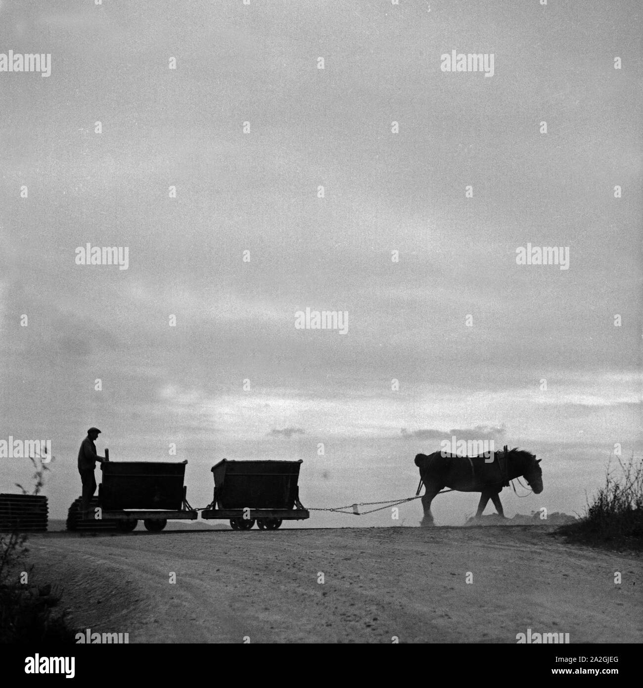 Ein Pferd zieht zwei Lorenwagen mit Erdaushub vom Bau der Reichsautobahn, Deutschland 1930er Jahe. Ein Pferd ziehen zwei Lkw mit Boden aus dem Bau der Reichsautobahn highwqay, Deutschland 1930. Stockfoto