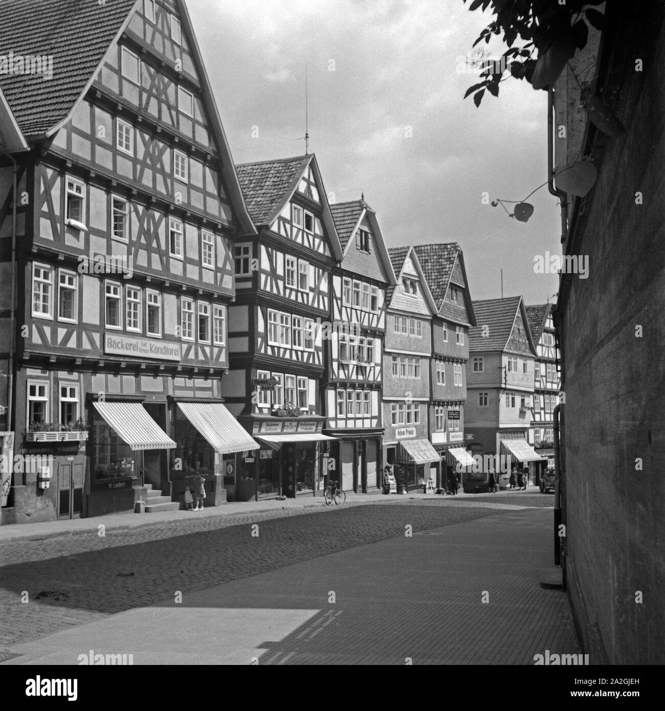 Einkaufs- und Geschäftsstraße in Bad Wildungen mit der Firma Bäckerei und Konditorei von Karl Brauer, Radiogeschäft und Ladenlokalen, Deutschland 1930er Jahre. Einkaufsstraße mit Bäckerei, Radio Shop und verschiedenen Verkaufsstellen in Bad Wildungen, Deutschland 1930. Stockfoto