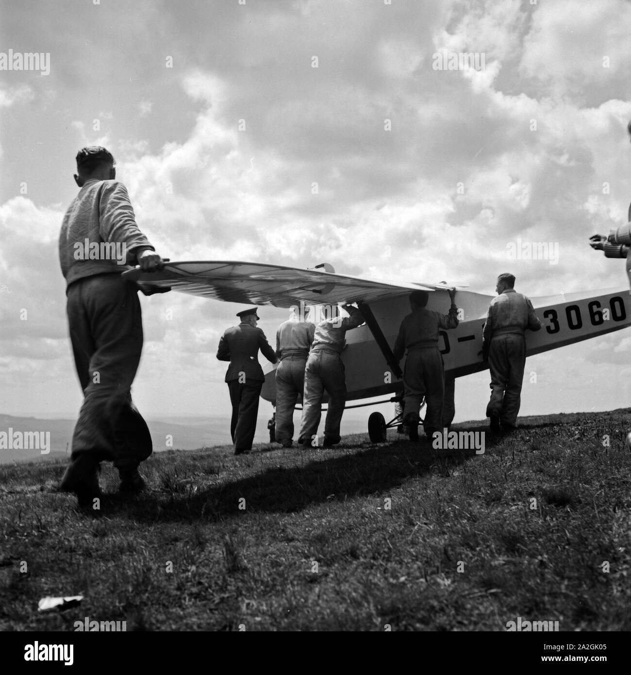 Hitlerjungen bewegen bei der Ausbildung auf der Reichssegelflugschule Wasserkuppe bei Fulda das Segelflugzeug 3060, Deutschland 1930er Jahre. Hitler Jugend an der Reichssegelflugschule für gleitflug an der Wasserkuppe in der Nähe von Fulda, Deutschland, 1930er Jahre ausgebildet. Stockfoto