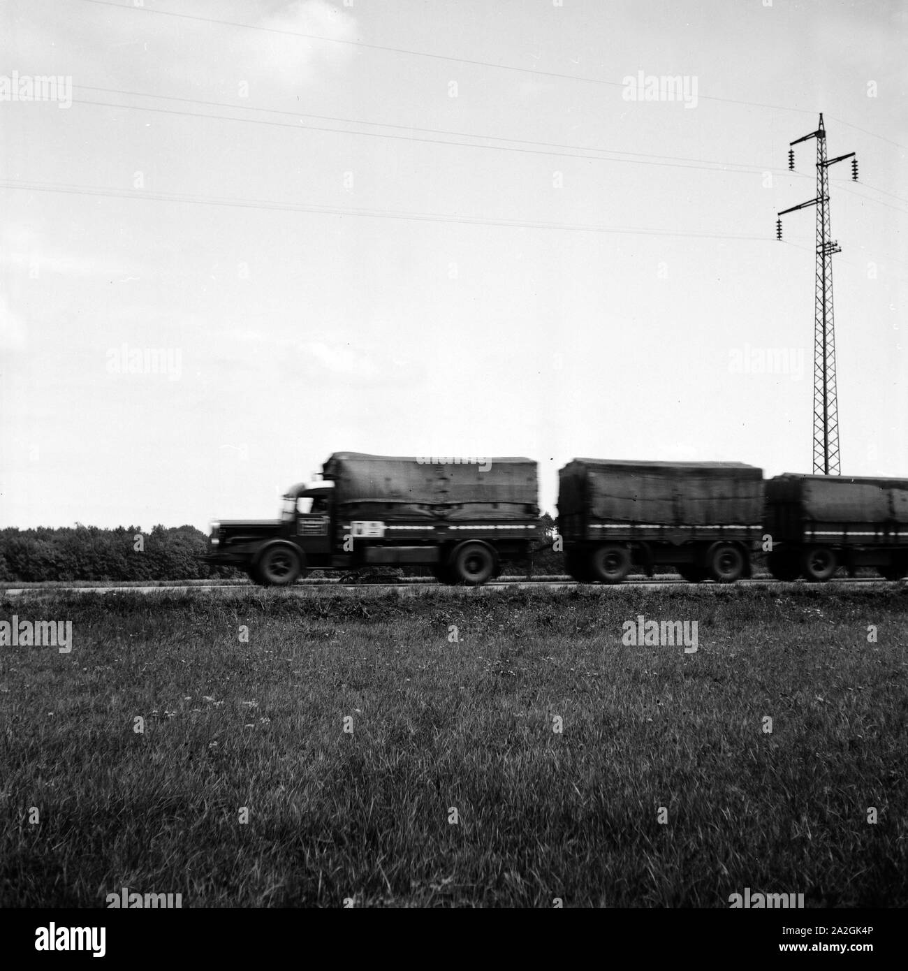 Ein LKW mit zwei Anhängern fährt durch die Landschaft der Rhön. Deutschland 1930er Jahre. Eine Zugmaschine mit zwei Anhängern auf dem Weg durch die Rhön, Deutschen 1930er. Stockfoto