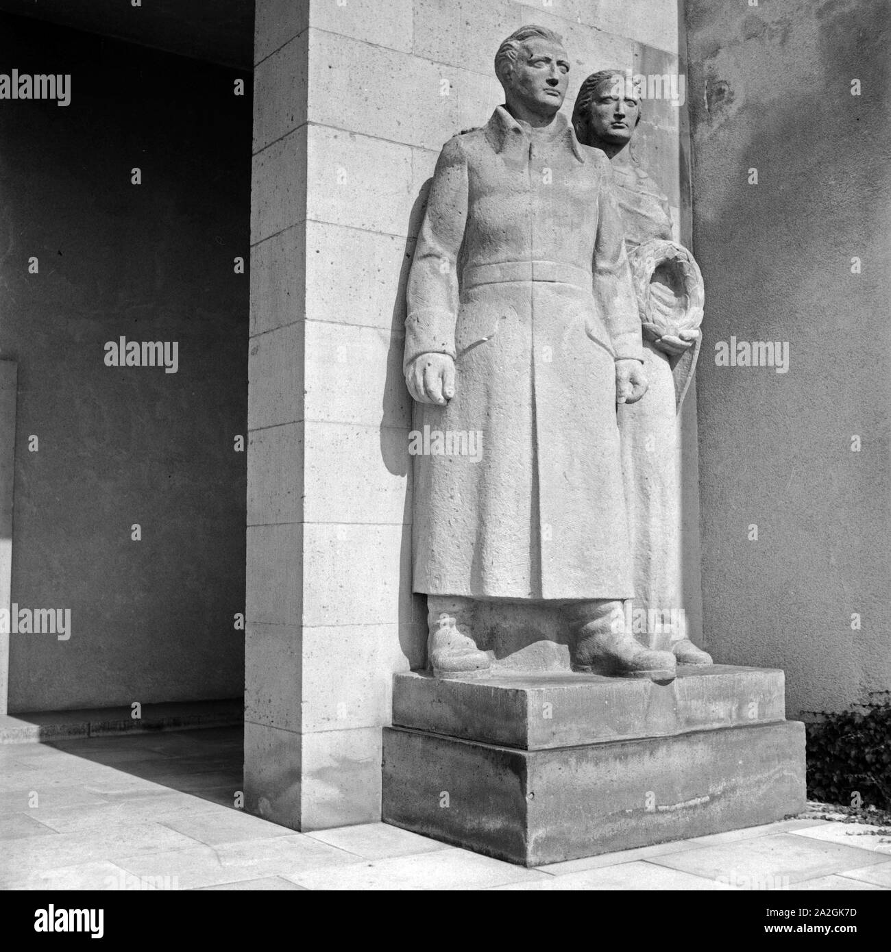 Figurengruppe Frau und Soldat bin Ehrenmal 'Dem deutschen Soldaten "für die Gefallenen des Ersten Weltkriegs, Deutschland 1930er Jahre. Skulptur Gruppe Frau und Soldat am Denkmal für die gefallenen Soldaten des Ersten Weltkriegs in Bad Nauheim, Deutschland 1930. Stockfoto