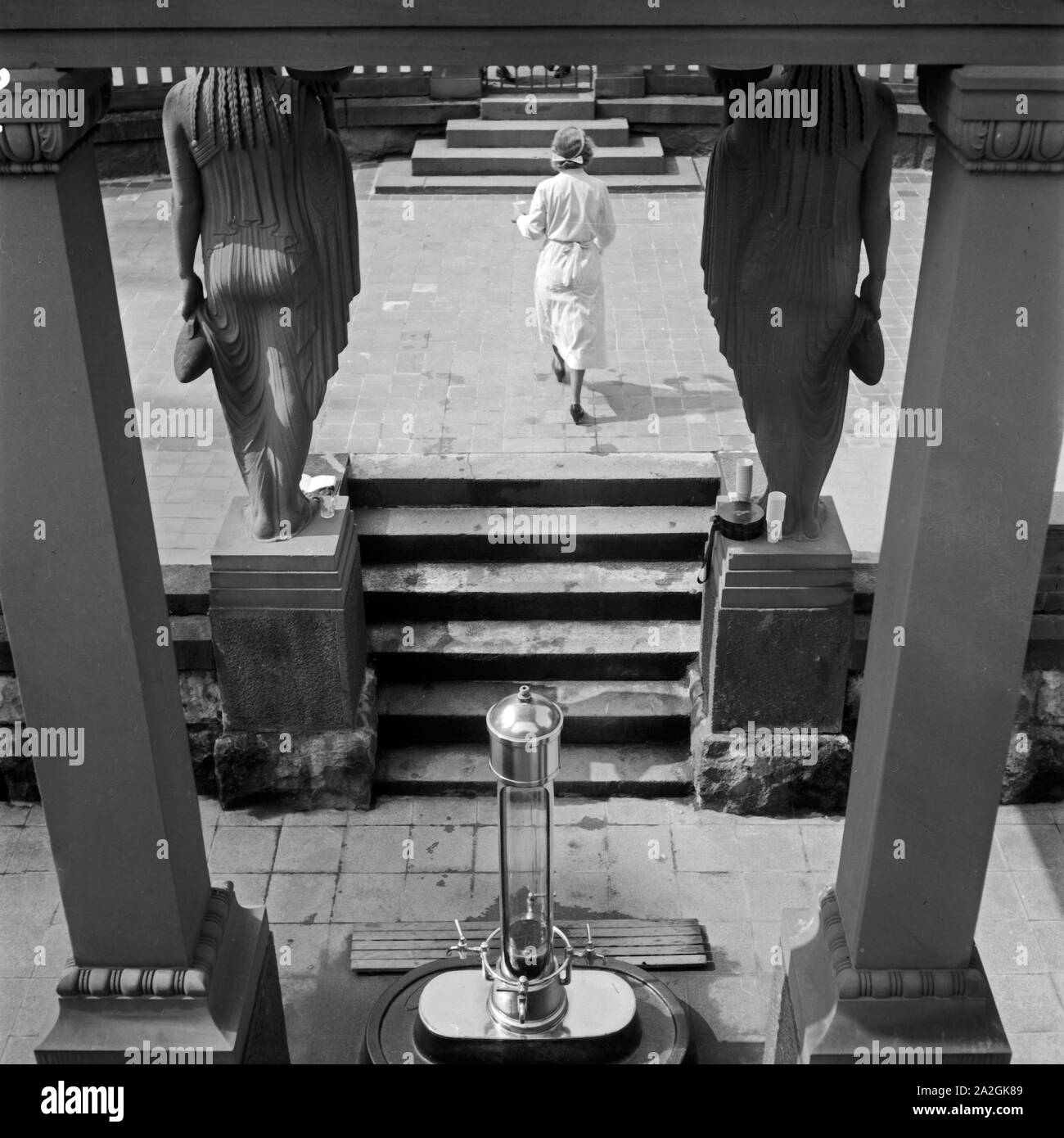 Eine Krankenschwester holt Kurgästen in Bad Homburg Wasser aus der Heilquelle, Deutschland 1930er Jahre. Eine Krankenschwester, die Wasser aus einer Heilquelle zu spa Gäste in Bad Homburg, Deutschland 1930. Stockfoto