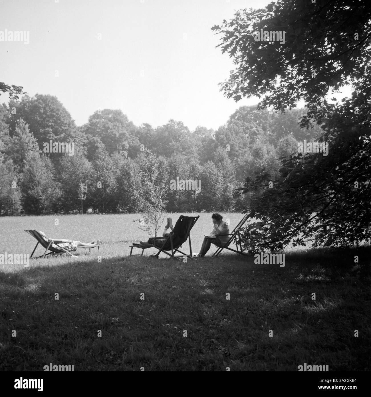Artikel Kurgäste in Sonnenstühlen im Kurpark von Bad Homburg, Deutschland 1930er Jahre. Spa entspannen Sie auf Liegestühlen in der Sonne in Bad Homburg, Deutschland 1930. Stockfoto