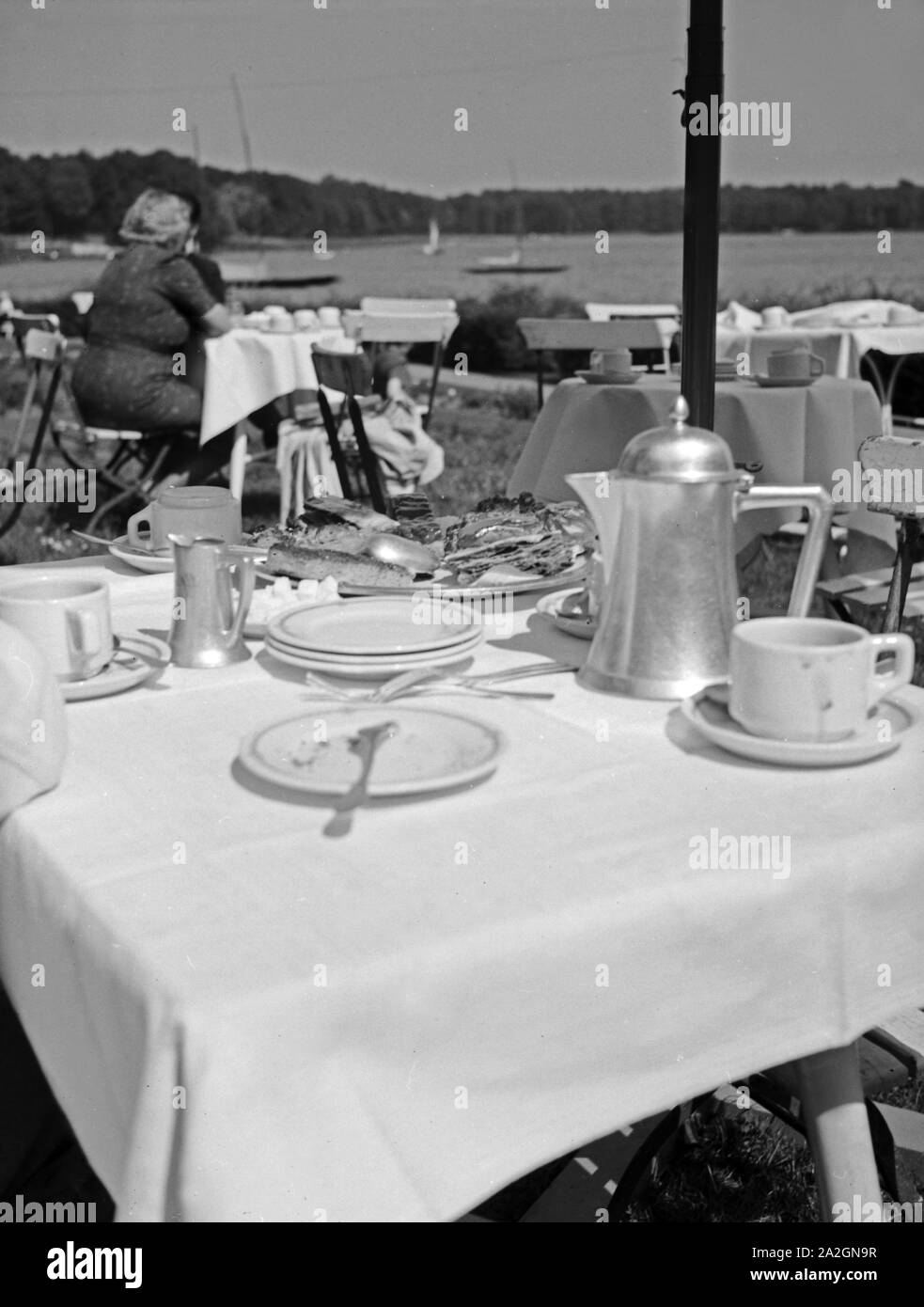 Gedeckte Kaffeetafel in der Außengastronomie, Deutschland 1930er Jahre. Perfekte Tabelle für Kaffee am Nachmittag, Deutschland 1930. Stockfoto