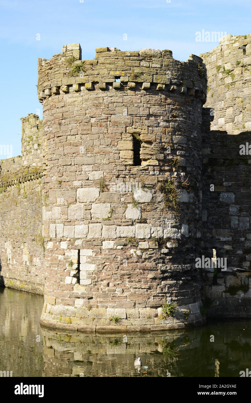 Eine der seitlichen Türme mit Reflexion in den Wassergraben in Beaumaris Castle auf Anglesey im Norden von Wales. Stockfoto